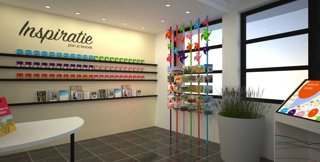 Interior of a visitor center with colorful windmill decorations, shelves with colorful brochures, a potted plant, and a digital display near large windows.