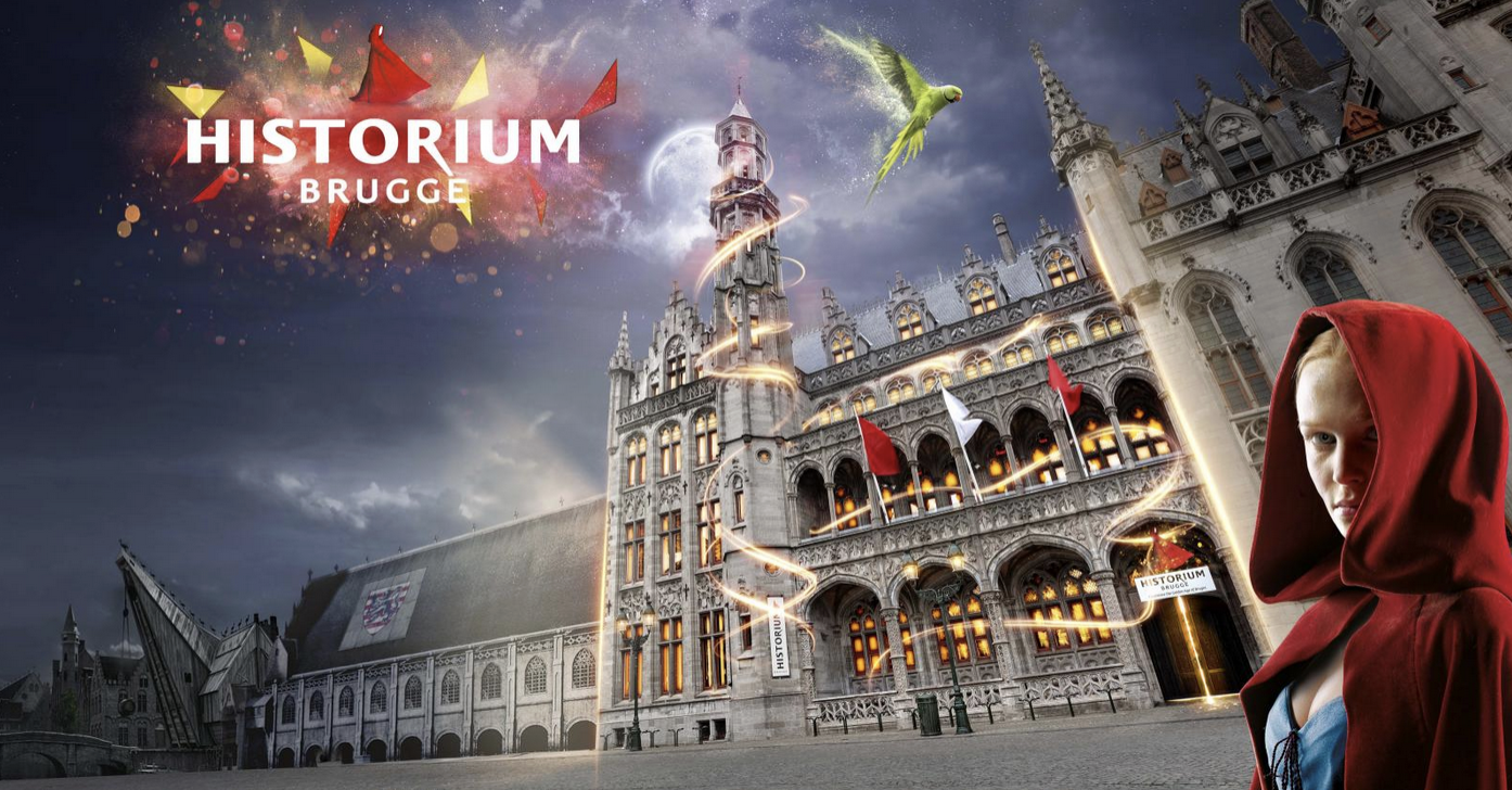 A young girl dressed as Little Red Riding Hood with a serious expression standing in front of a gothic-style building with glowing windows and a sign that reads "HISTORIUM BRUGGE." The building is animated with swirling lights, flying flags, a full moon in the sky, and a parrot flying above.