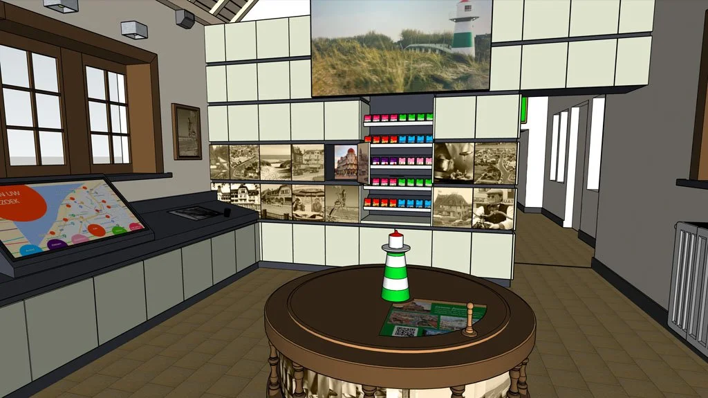 An indoor exhibit with a nautical theme. It features a large table with a small model lighthouse, a map, and pamphlets. Shelf displays showcase colorful bottles and black-and-white vintage photographs, with a large screen on the wall showing a lighth