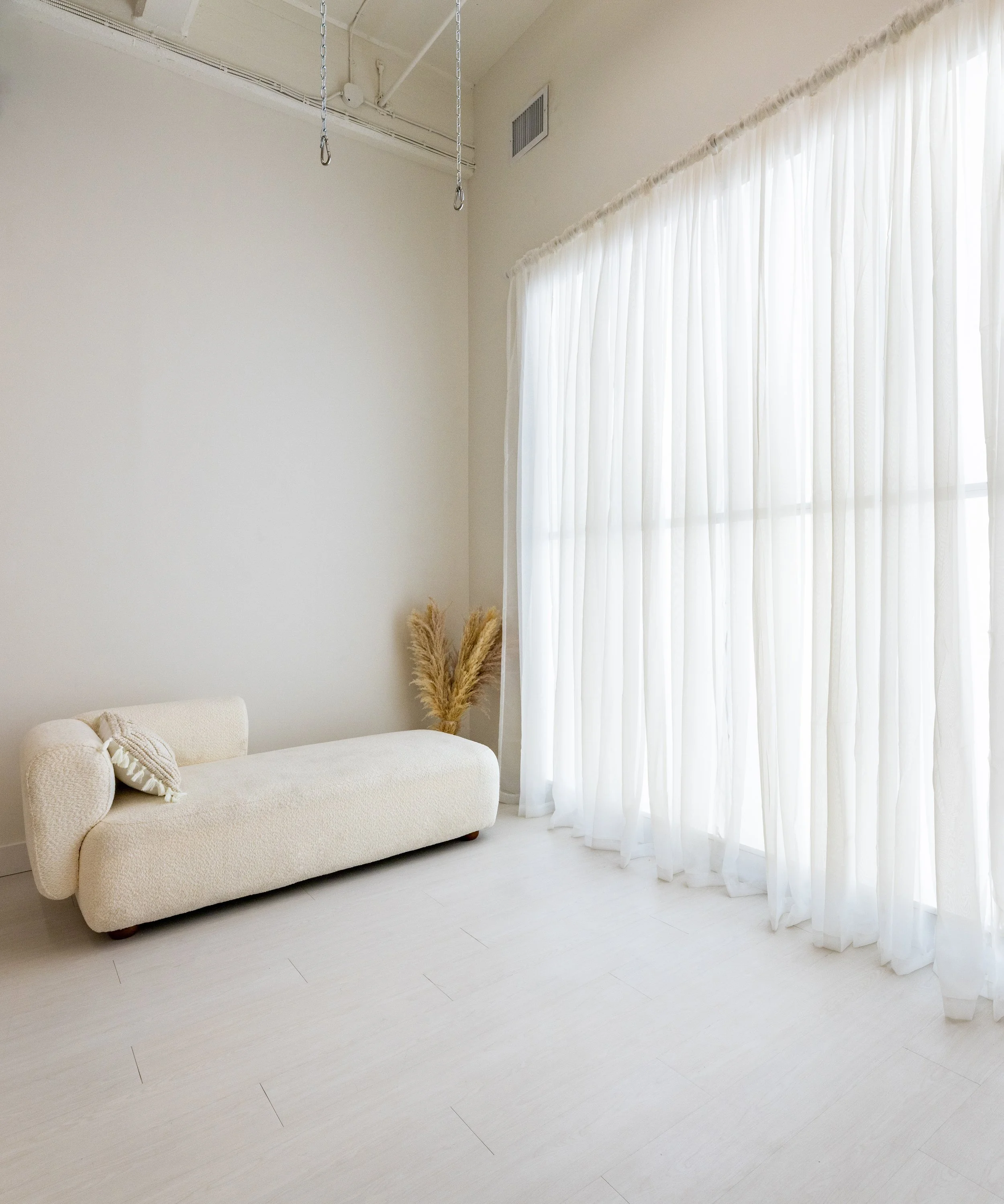 Natural light photography corner with sheer curtains at Little Light Studio
