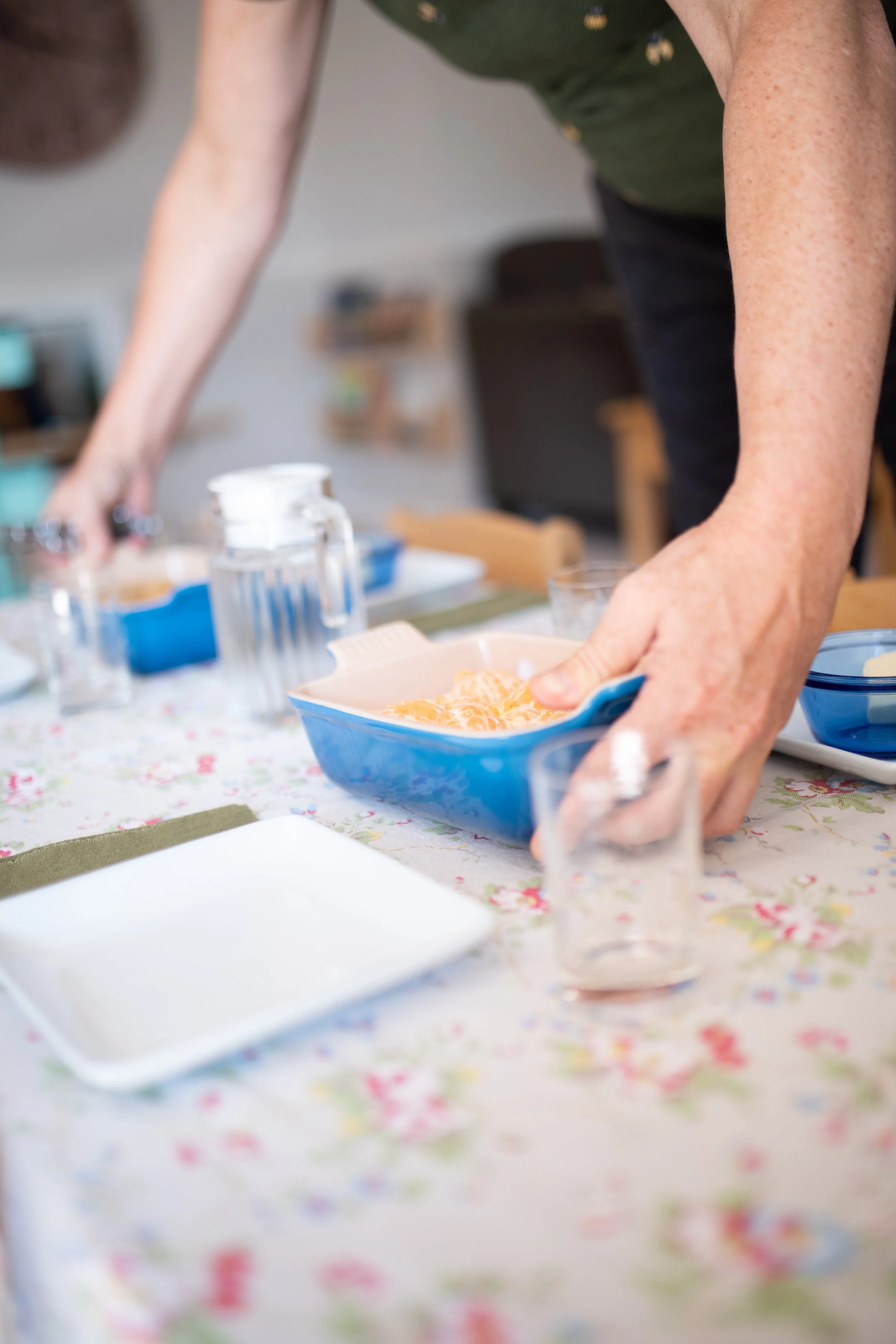 hands placing snacks on a prepared table