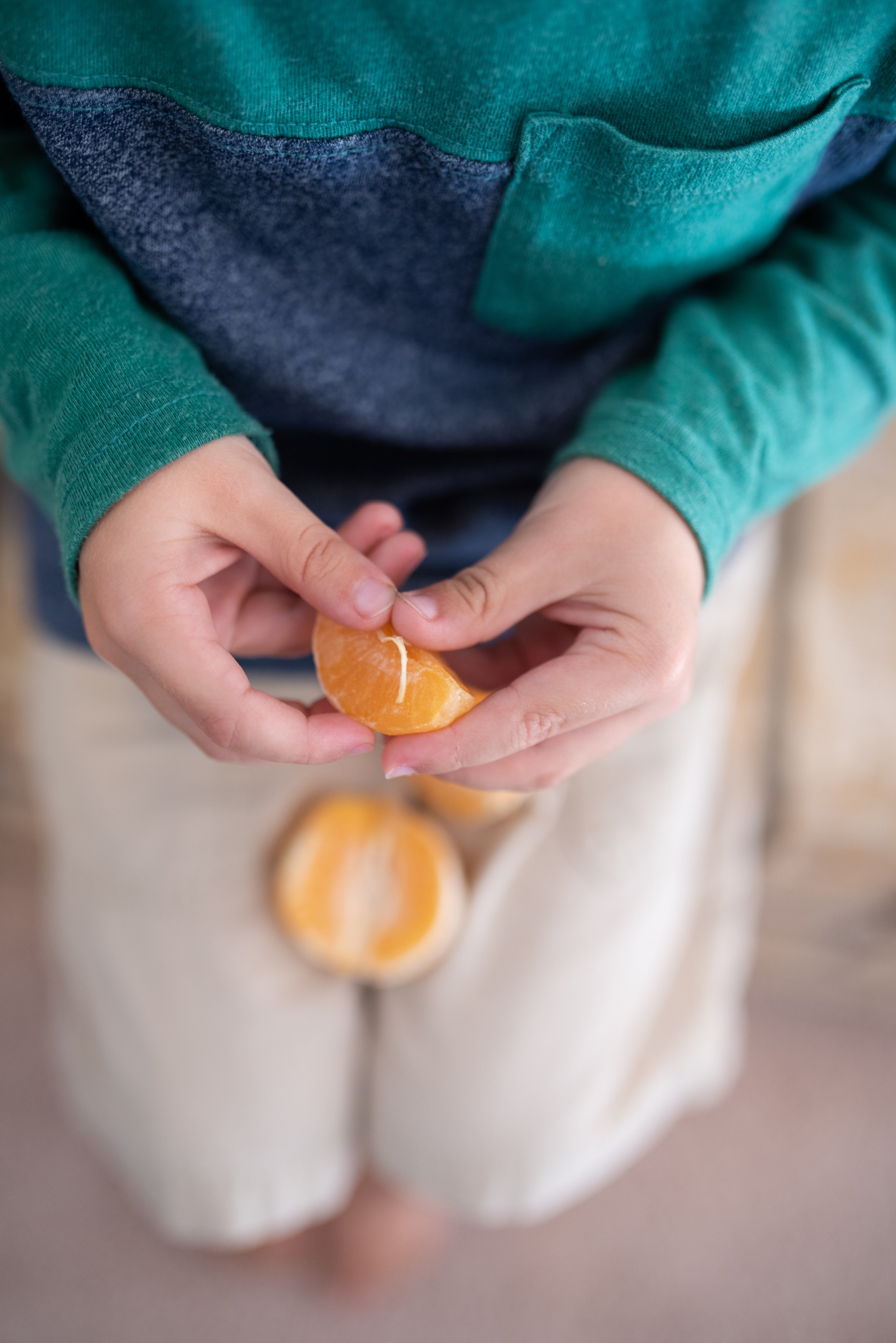 child peeling an orange