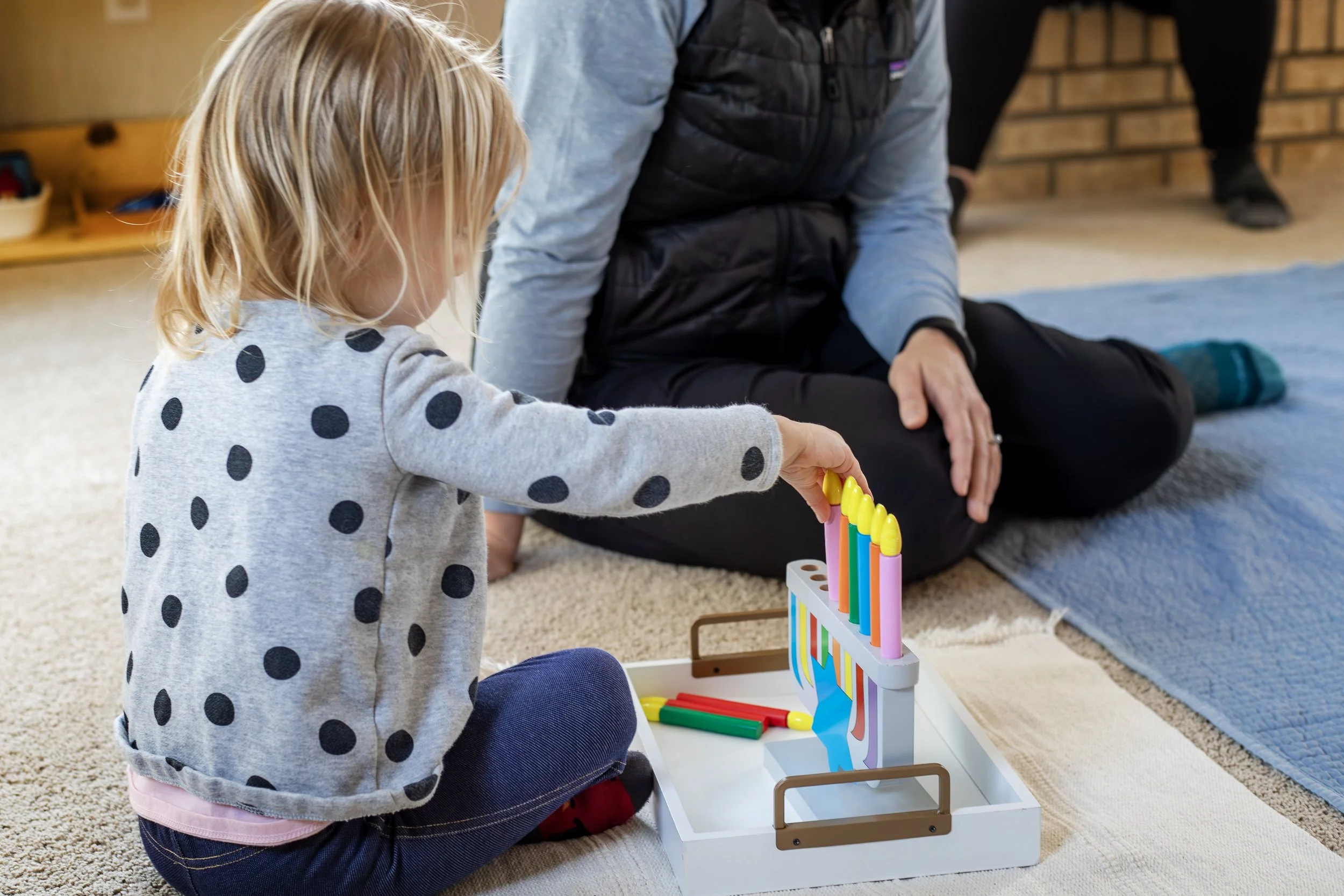 girl playing with montessori toys in play room