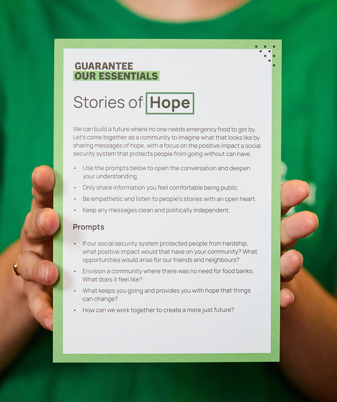 Someone is holding up a piece of paper which reads 'Stories of hope'. It has information on it to help people encourage other people to open up about their stories