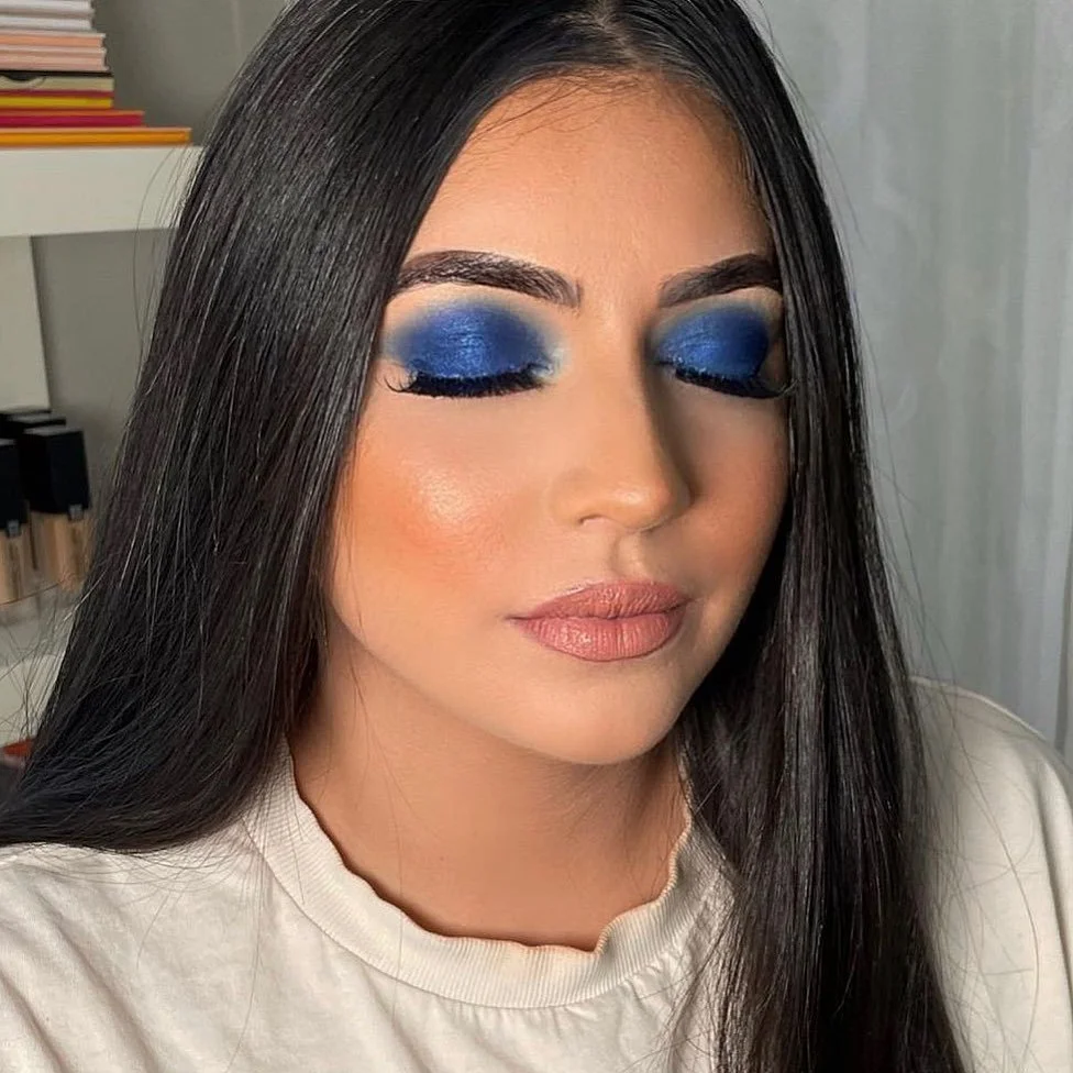 Client wearing New Year glam makeup with glowing skin, shimmering eyeshadow, bold lashes, and a glossy lip by Makeupologyy in New Rochelle, NY
