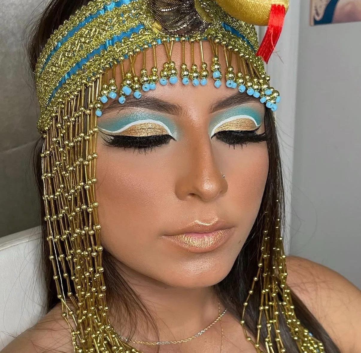 Client wearing customized Halloween makeup with bold colors, dramatic shading, and artistic costume details by Makeupologyy