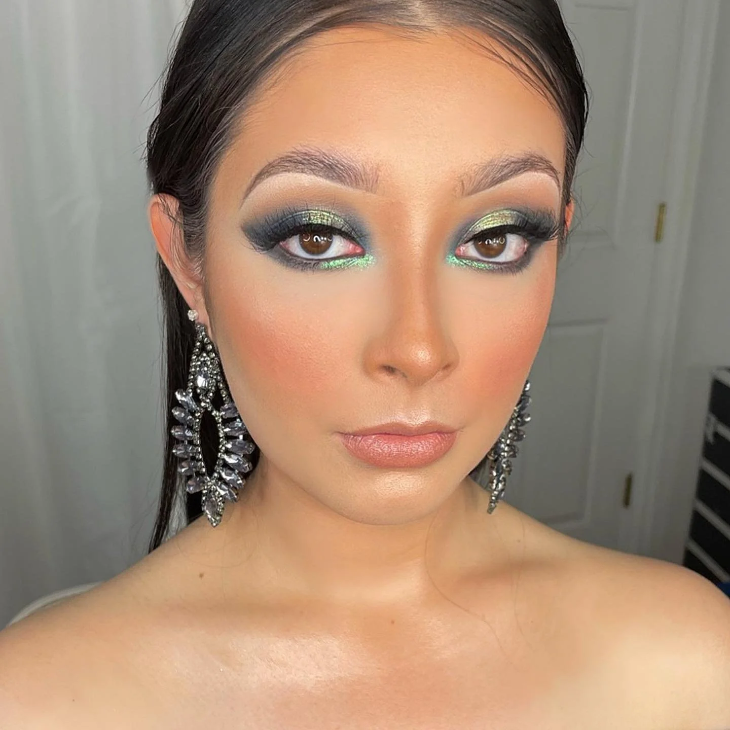 Client wearing halo eye makeup with a bright blue-green shimmering eyeshadow, deeper blended corners, and defined lashes by Makeupologyy