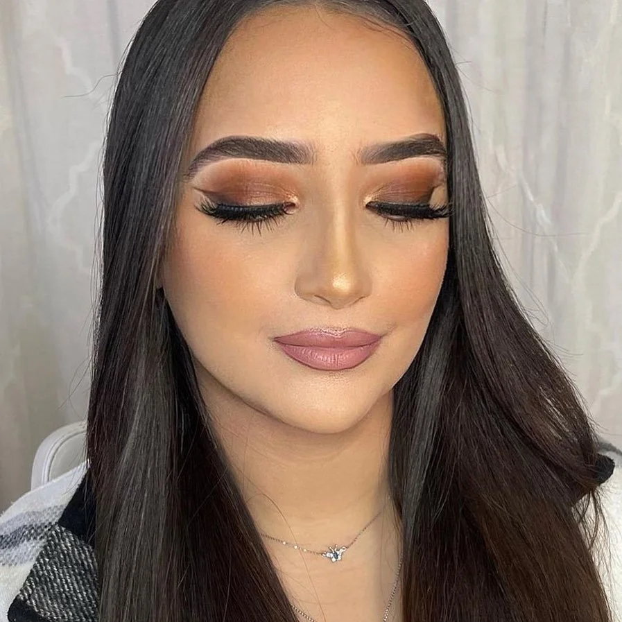 Client wearing bronzy glam makeup with warm golden tones, glowing skin, and softly defined eyes