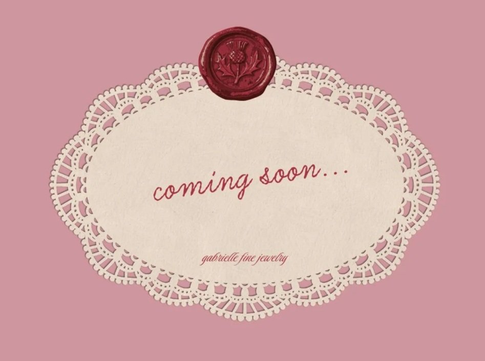 Pink background with white doily-like border and a wax seal at the top. Text in the center reads "coming soon..." and "gabrielle fine jewelry."