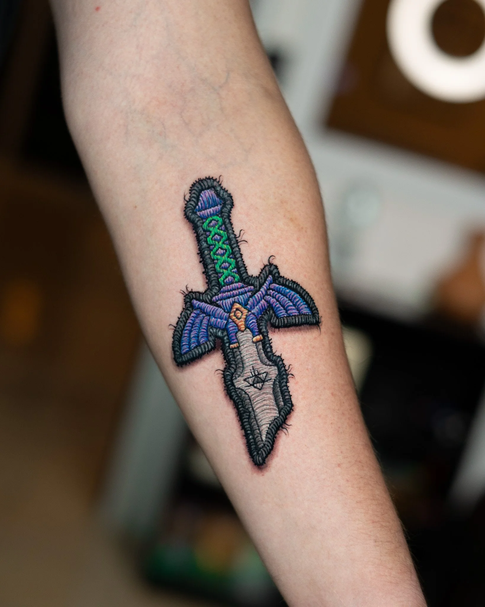 Tatuaje estilo bordado de una espada, tatuaje estilo parche hecho en Antigua Guatemala, Guatemala. Tatuaje tejido, tatuaje con efecto de hilos. Tatuaje hecho por Benjamin Saenz en Antigua Guatemala, en el tattoo shop: Sublime Tattoo Antigua.