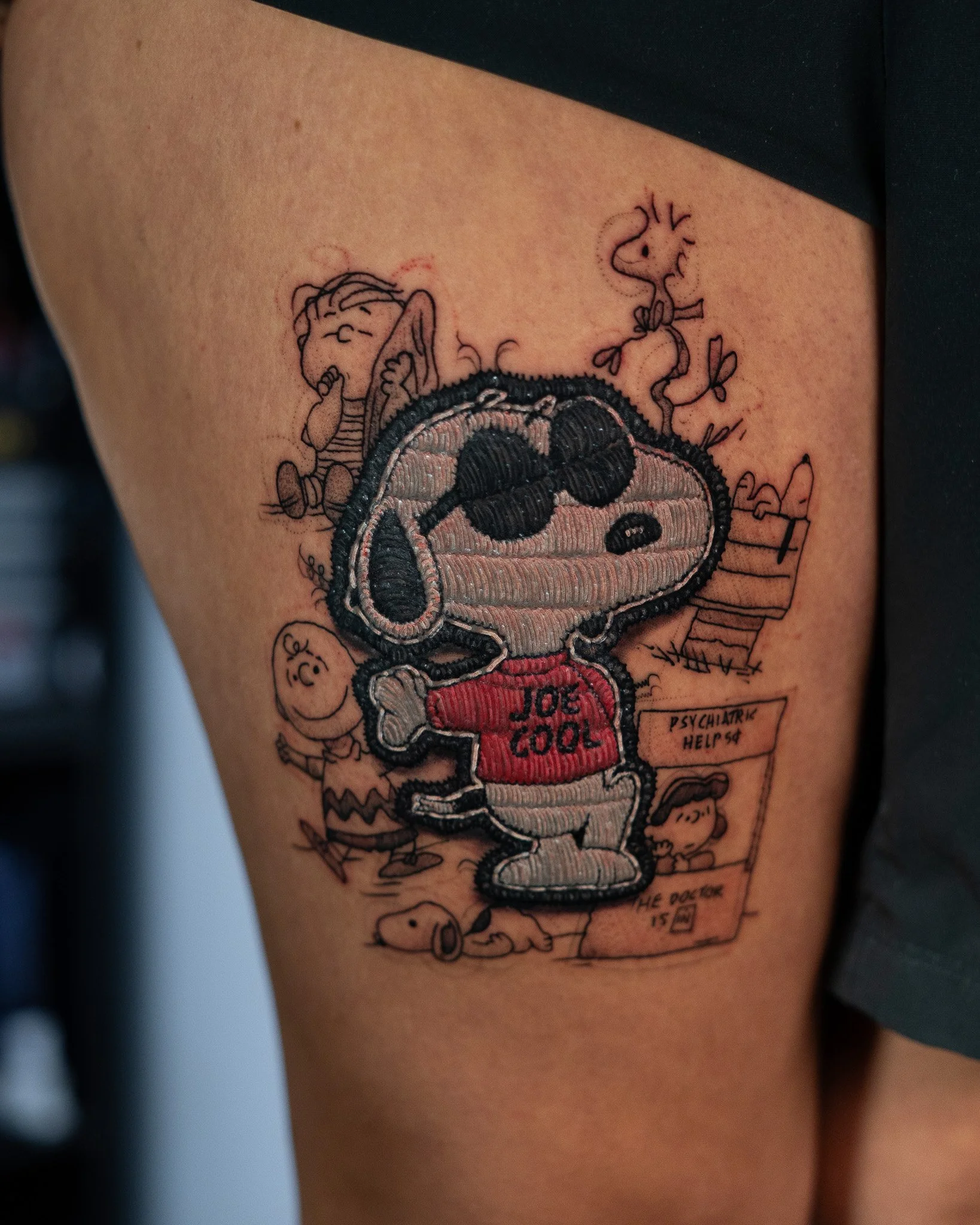 Tatuaje de Snoopy con leyenda 'JUE COOL'.  estilo bordado de un perro, tatuaje estilo parche hecho en Antigua Guatemala, Guatemala. Tatuaje tejido, tatuaje con efecto de hilos. Tatuaje hecho por Benjamin Saenz en Antigua Guatemala
