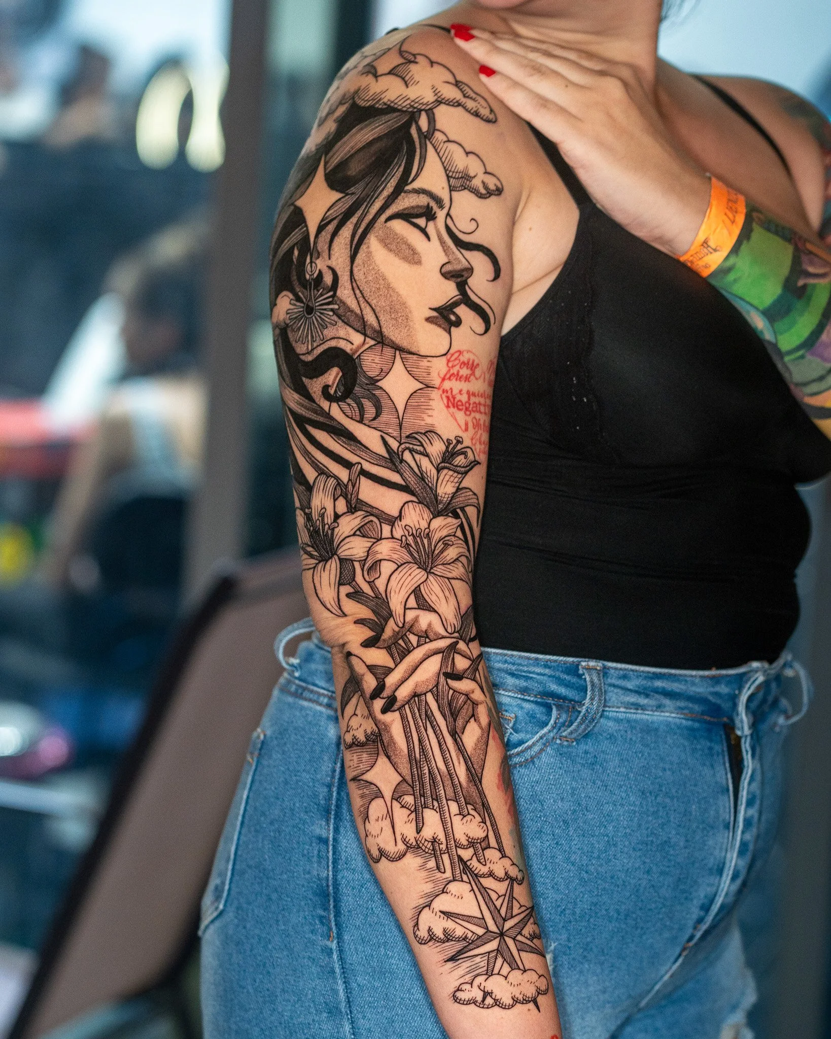 Mujer con tatuaje grande en el brazo que muestra una ilustración de perfil de una mujer, letras y flores. Linework, blackwork. Hecho en Antigua Guatemala, Guatemala. Tatuaje hecho por Benjamin Saenz en Antigua Guatemala.