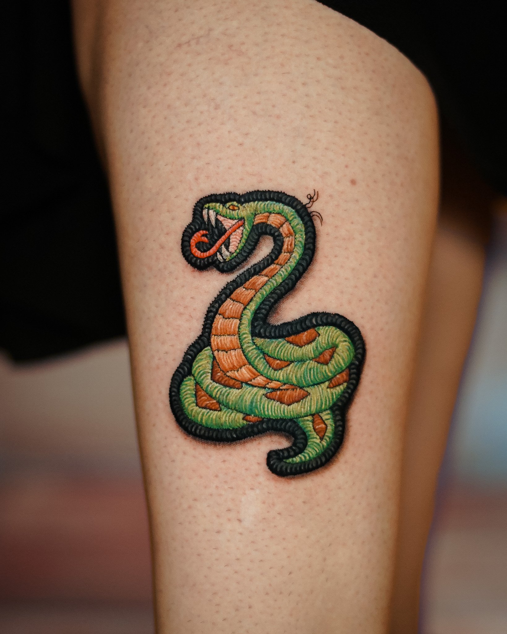 Tatuaje de una serpiente entrelazada en el brazo.