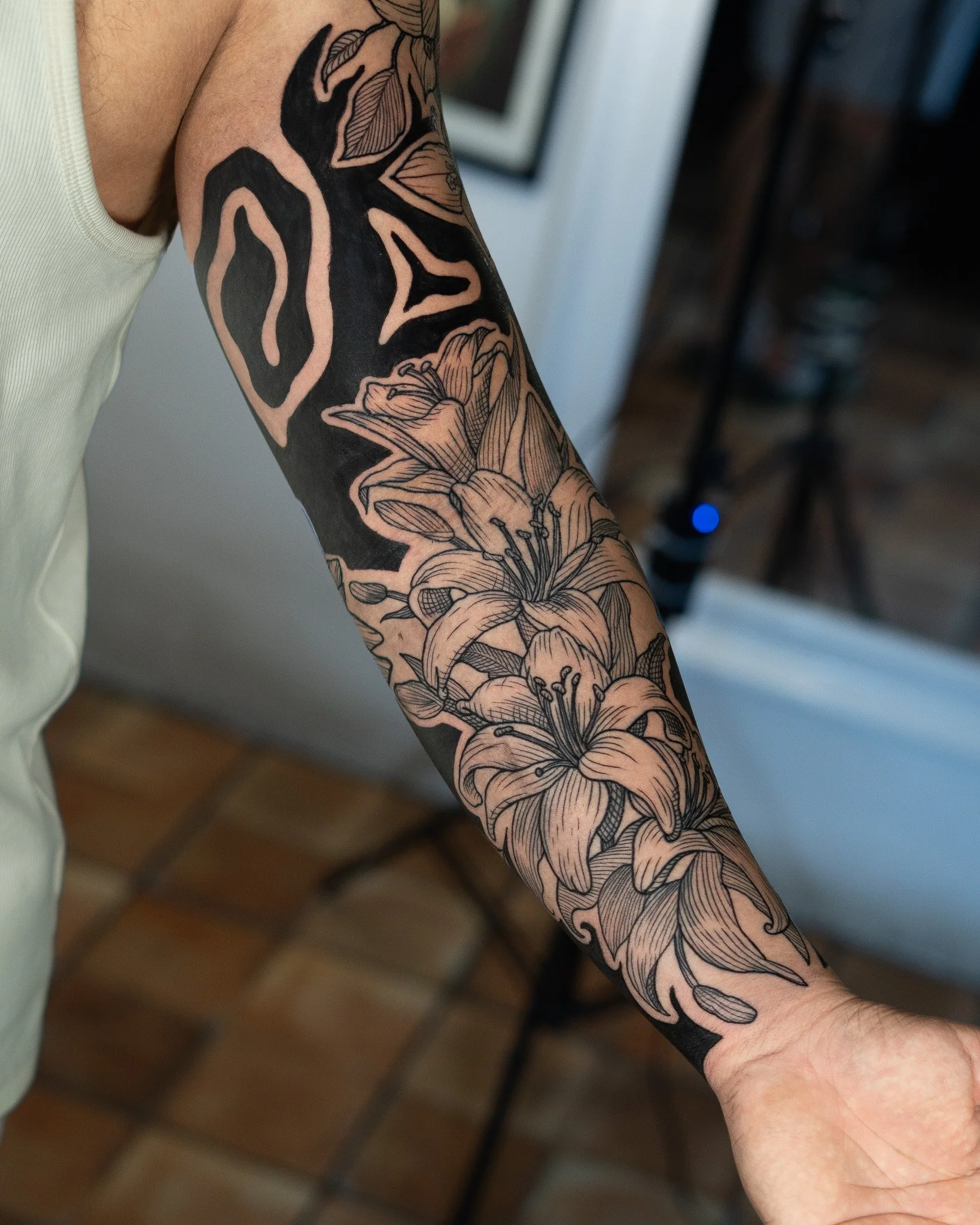Tatuaje en el brazo que muestra flores y líneas negras en estilo de línea delgada. estilo grabado, etching, woodcut, linework, blackwork. Hecho en Antigua Guatemala, Guatemala. Tatuaje hecho por Benjamin Saenz en Antigua Guatemala.