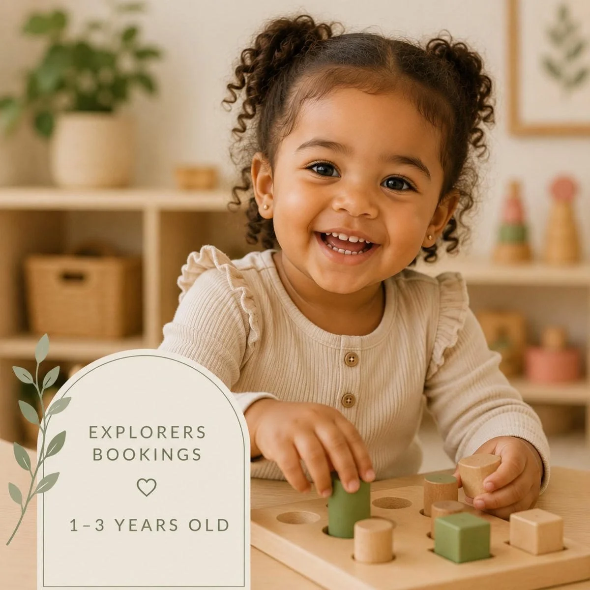 A smiling young girl with curly hair playing with wooden blocks at a table in a cozy, decorated room.