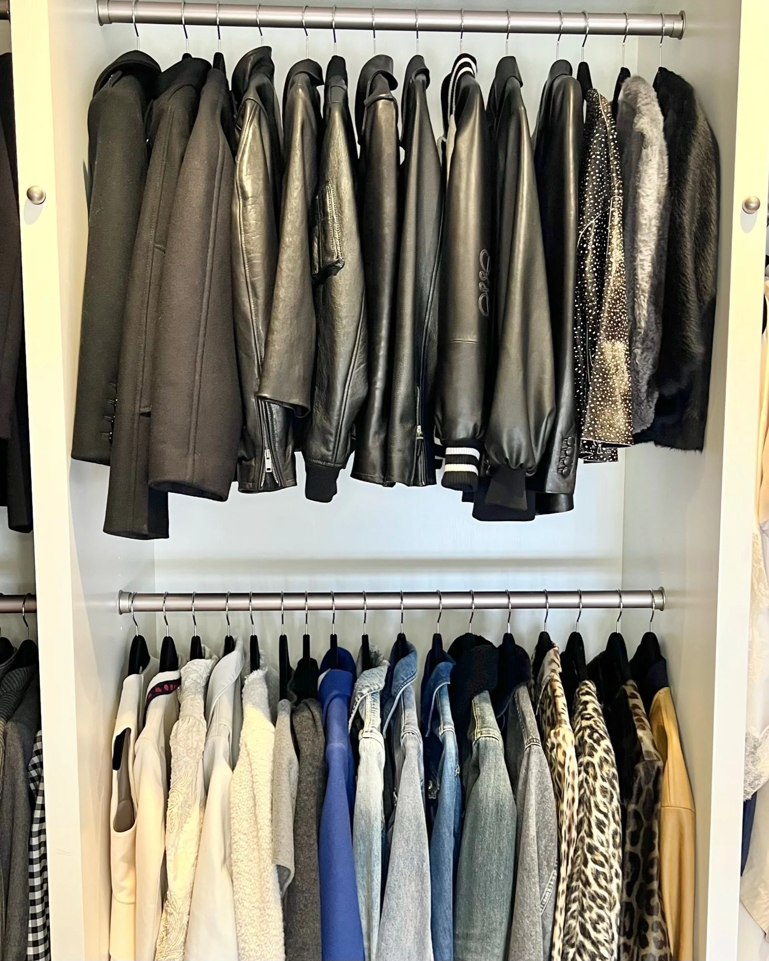 Organized closet with leather jackets and hanging clothing
