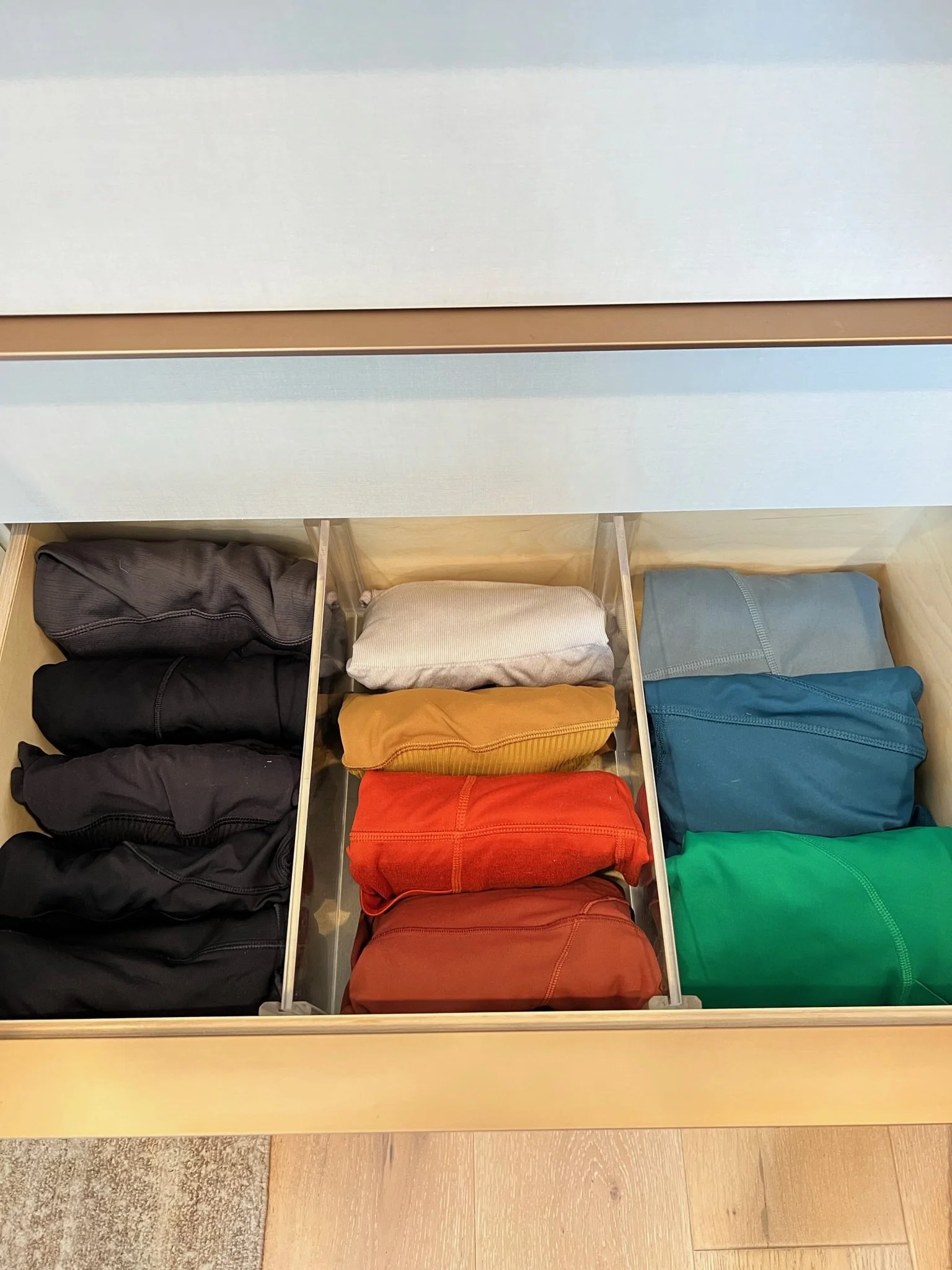Custom drawer with color-sorted folded clothing