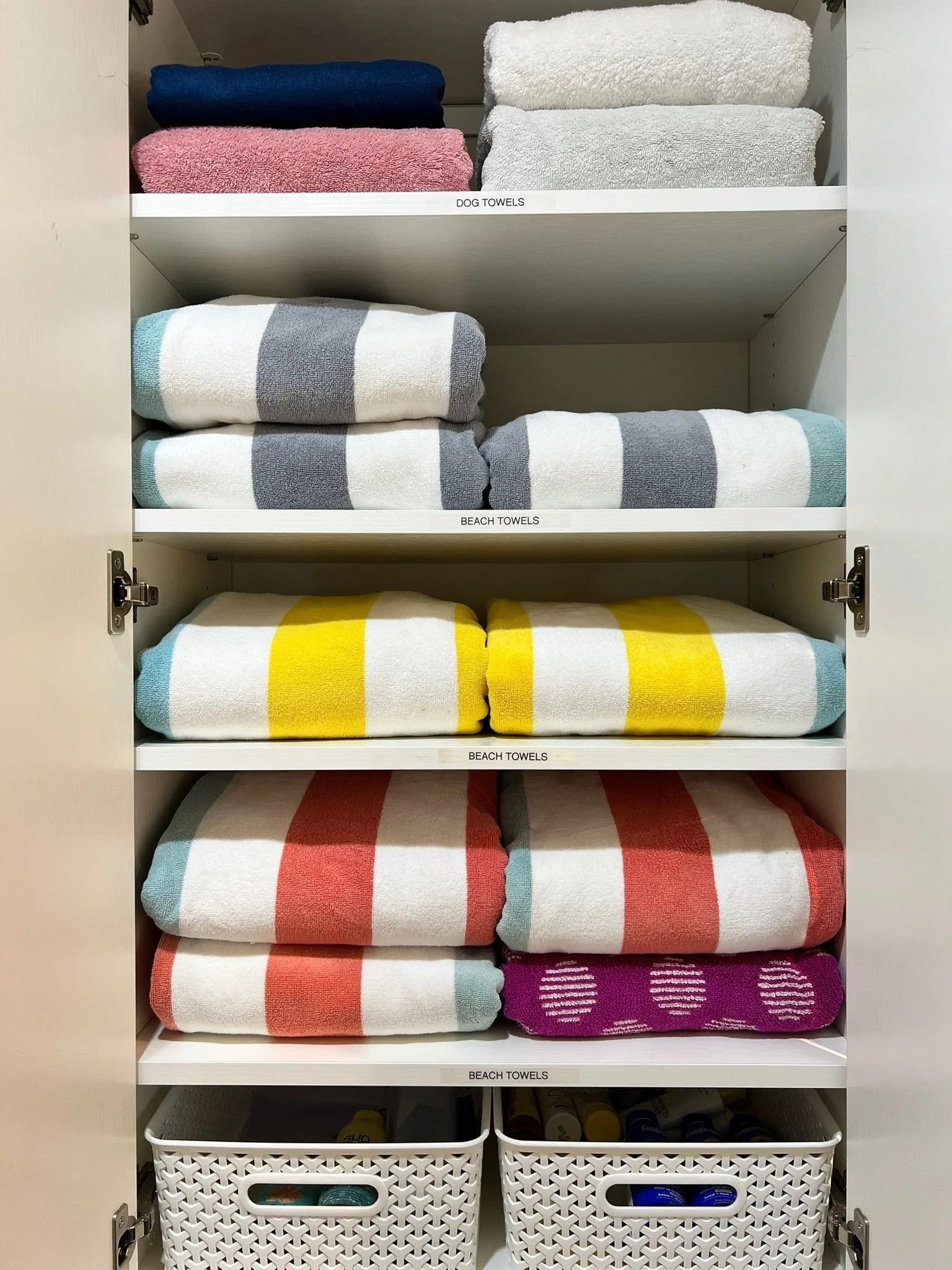 Organized linen closet with color-coordinated rolled towels