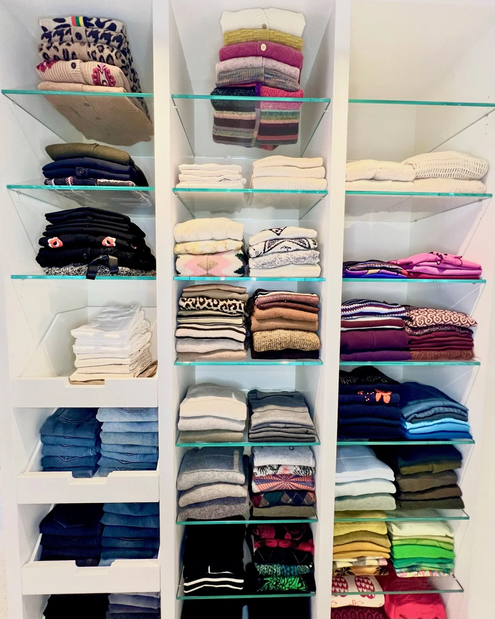 Custom closet shelving with folded, color-sorted clothing