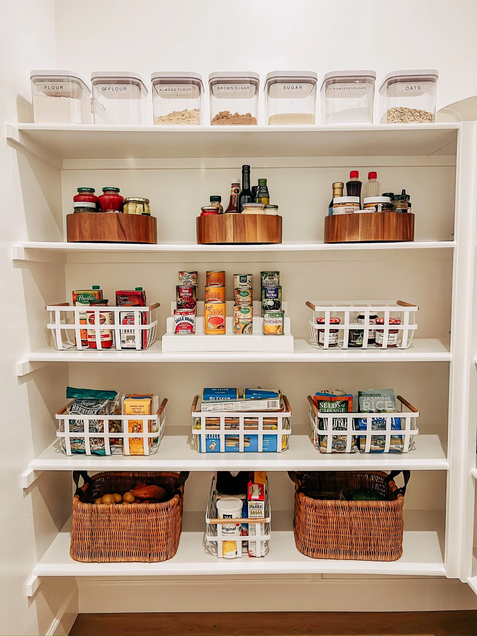 Professionally organized pantry with baskets and wooden turntables