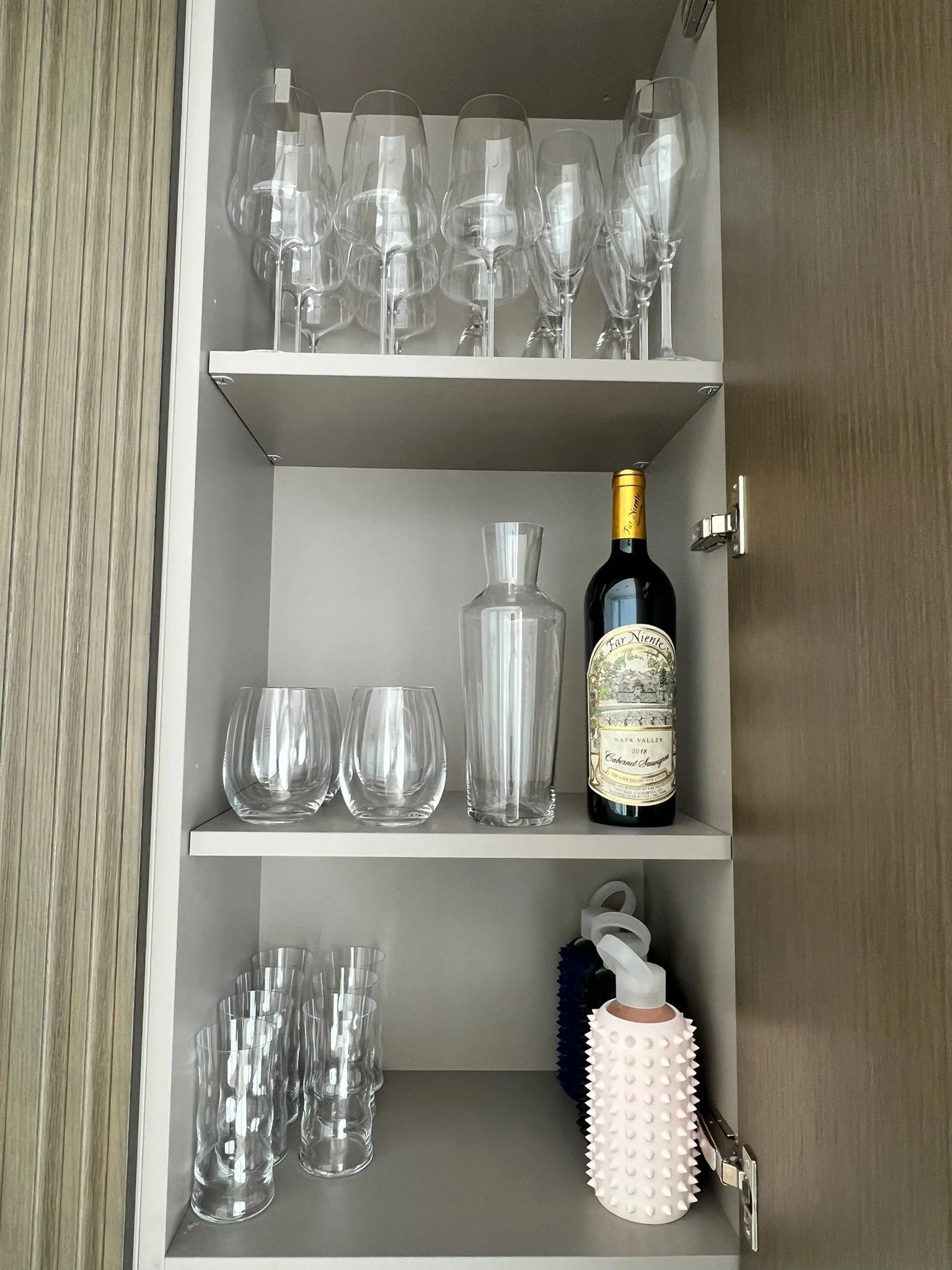 Organized bar cabinet with glassware and wine storage