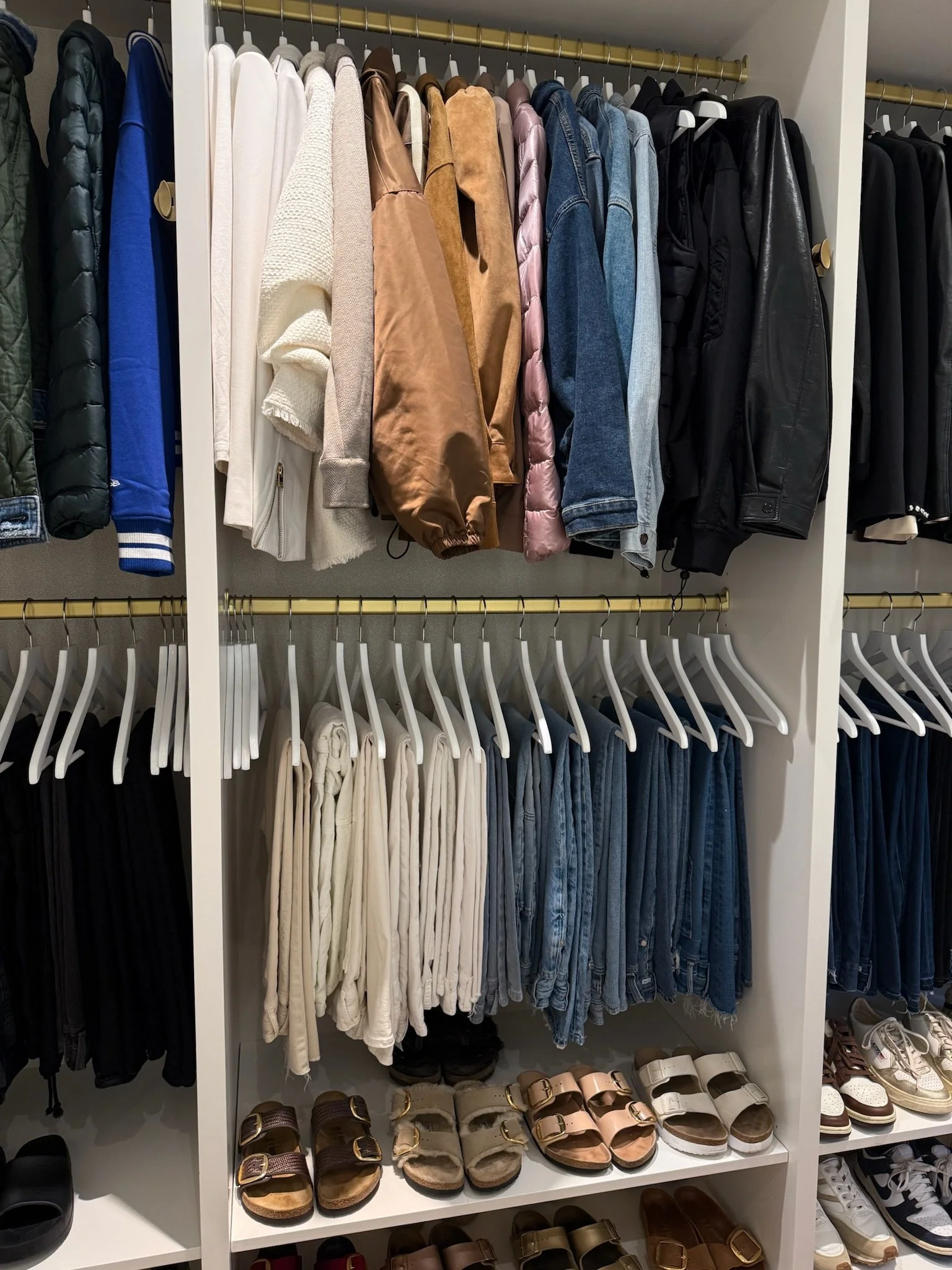 Organized closet with hanging clothing and folded stacks