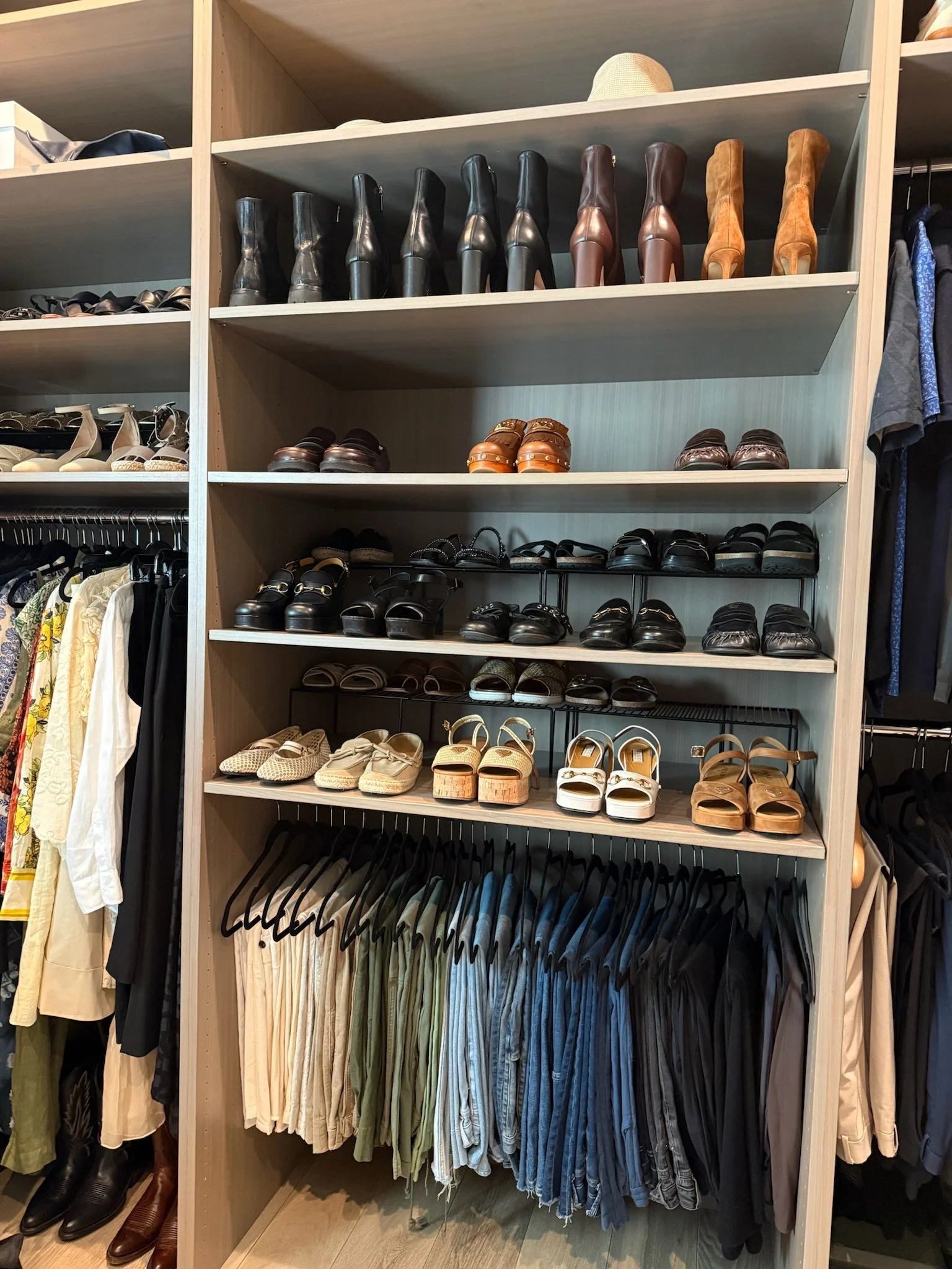 Custom closet with organized shoes and hanging clothing
