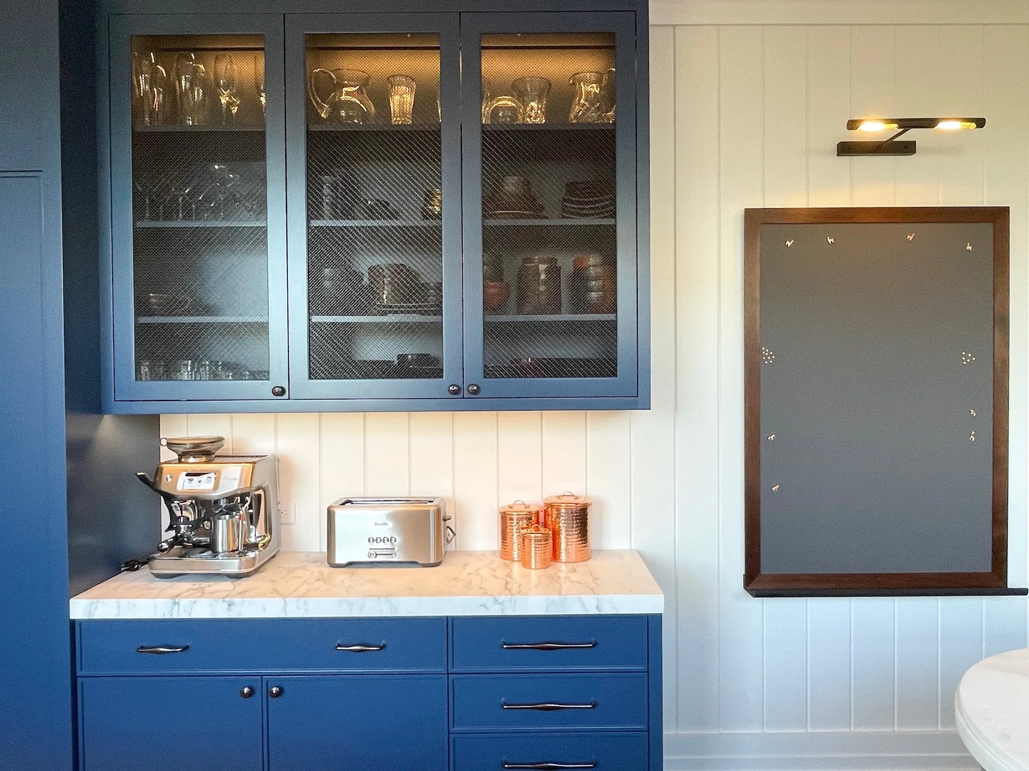 Luxury navy butler's pantry with glass-front cabinets and coffee station