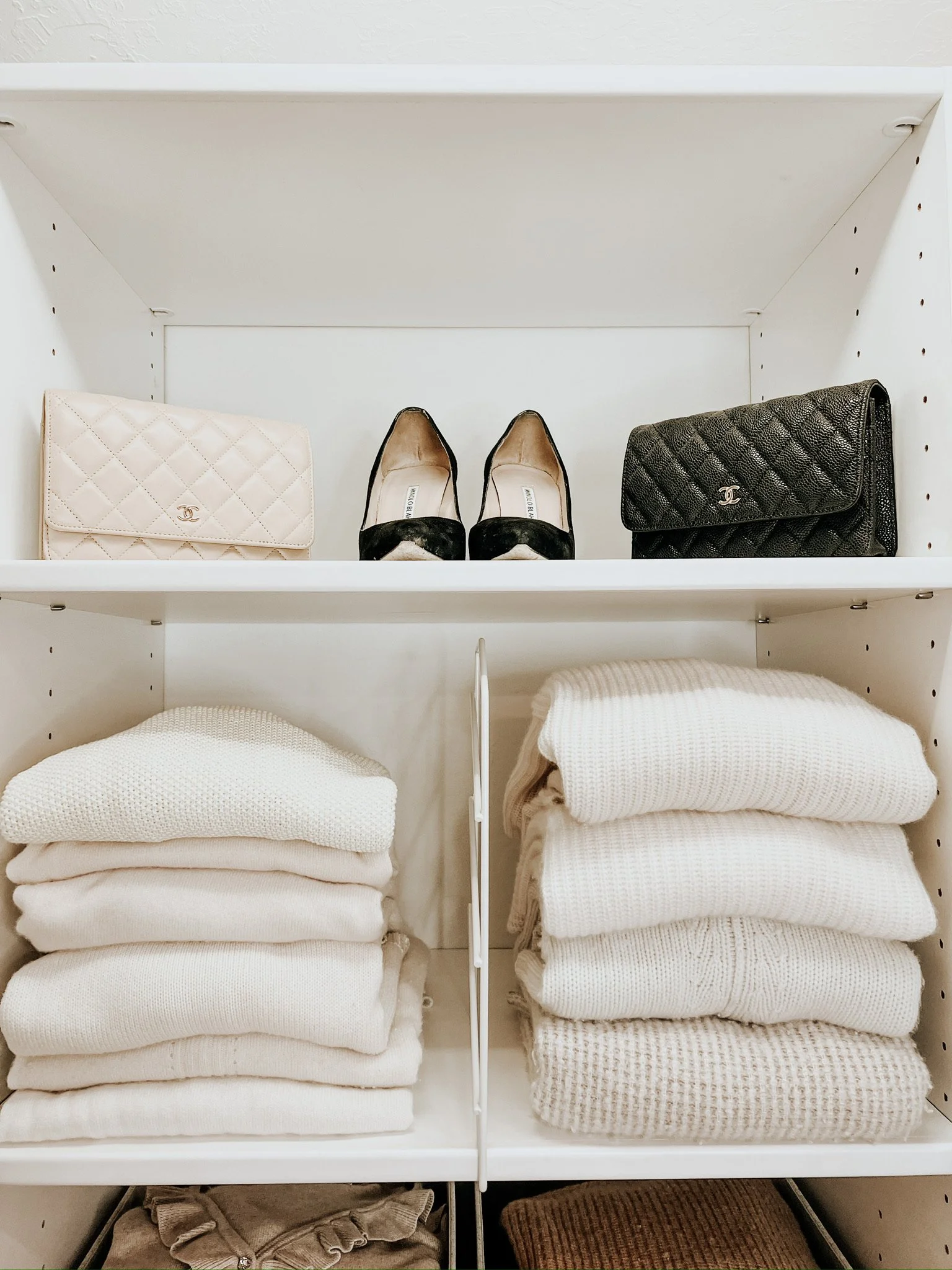Professionally organized luxury closet with Chanel bags and white sweaters
