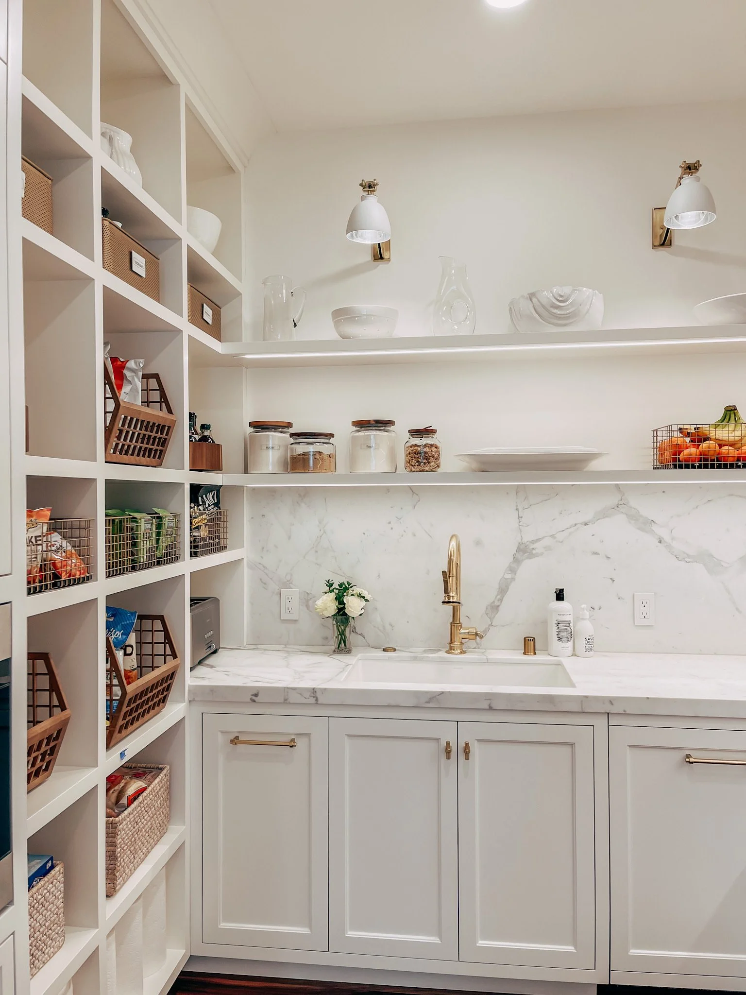 Luxury butler's pantry with marble counters and glass storage