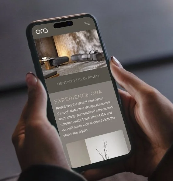 Person holding a smartphone displaying a dental clinic app with the text 'DENTISTRY REDEFINED' and information about dental experience.