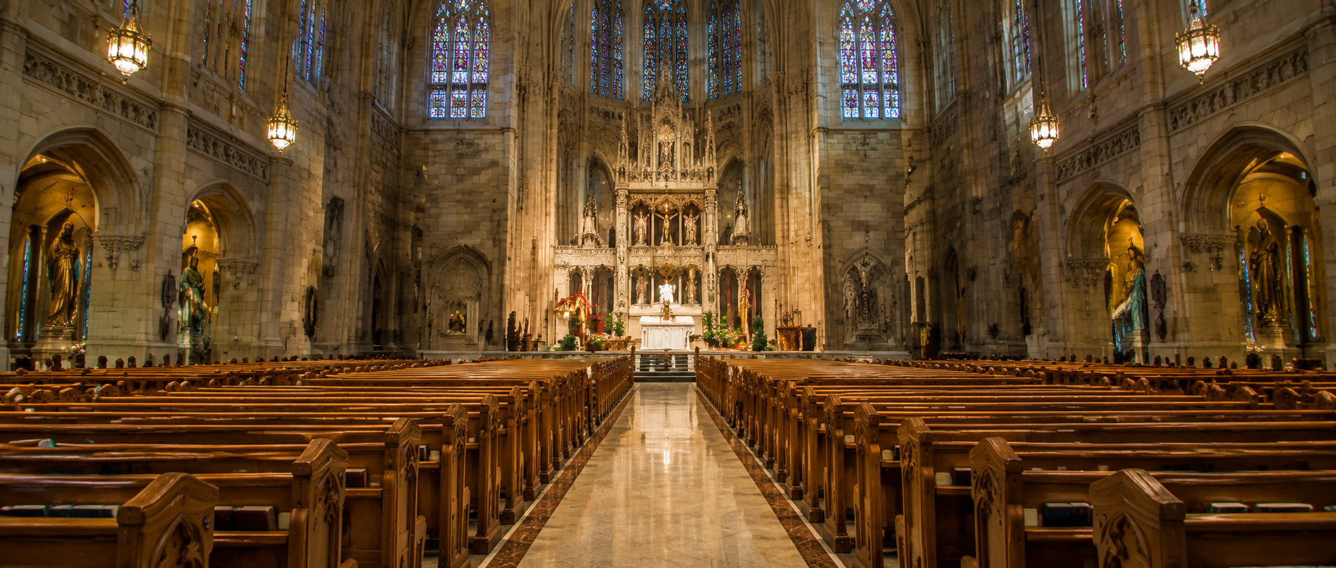 Gleaming marble aisle floor in a church sanctuary, reflecting the surrounding pews and altar, showcasing the results of professional floor cleaning and maintenance.