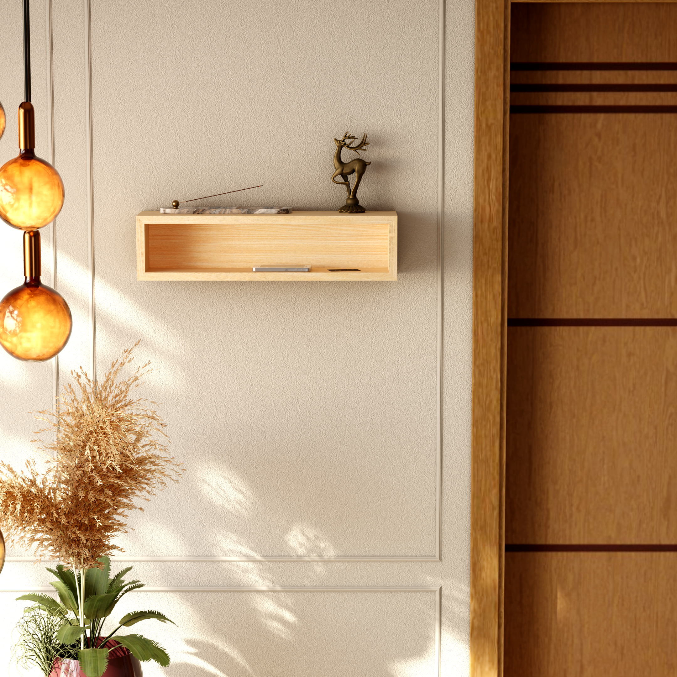 A potted plant with green leaves and dried beige flowers placed on a wooden surface against a beige wall. A decorative brass reindeer statue and a rectangular marble tray are on the wall shelf.