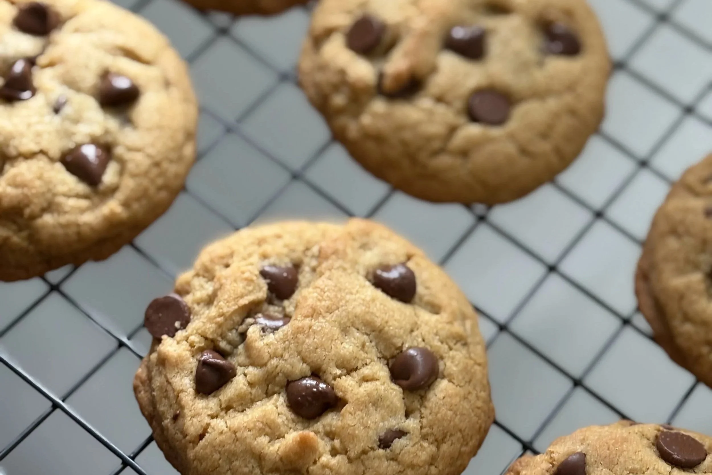 Chocolate chip cookies cooling on a wire rack.