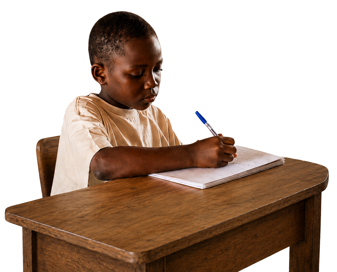 A young boy with a short haircut sitting at a wooden desk, writing in a notebook with a blue pen.