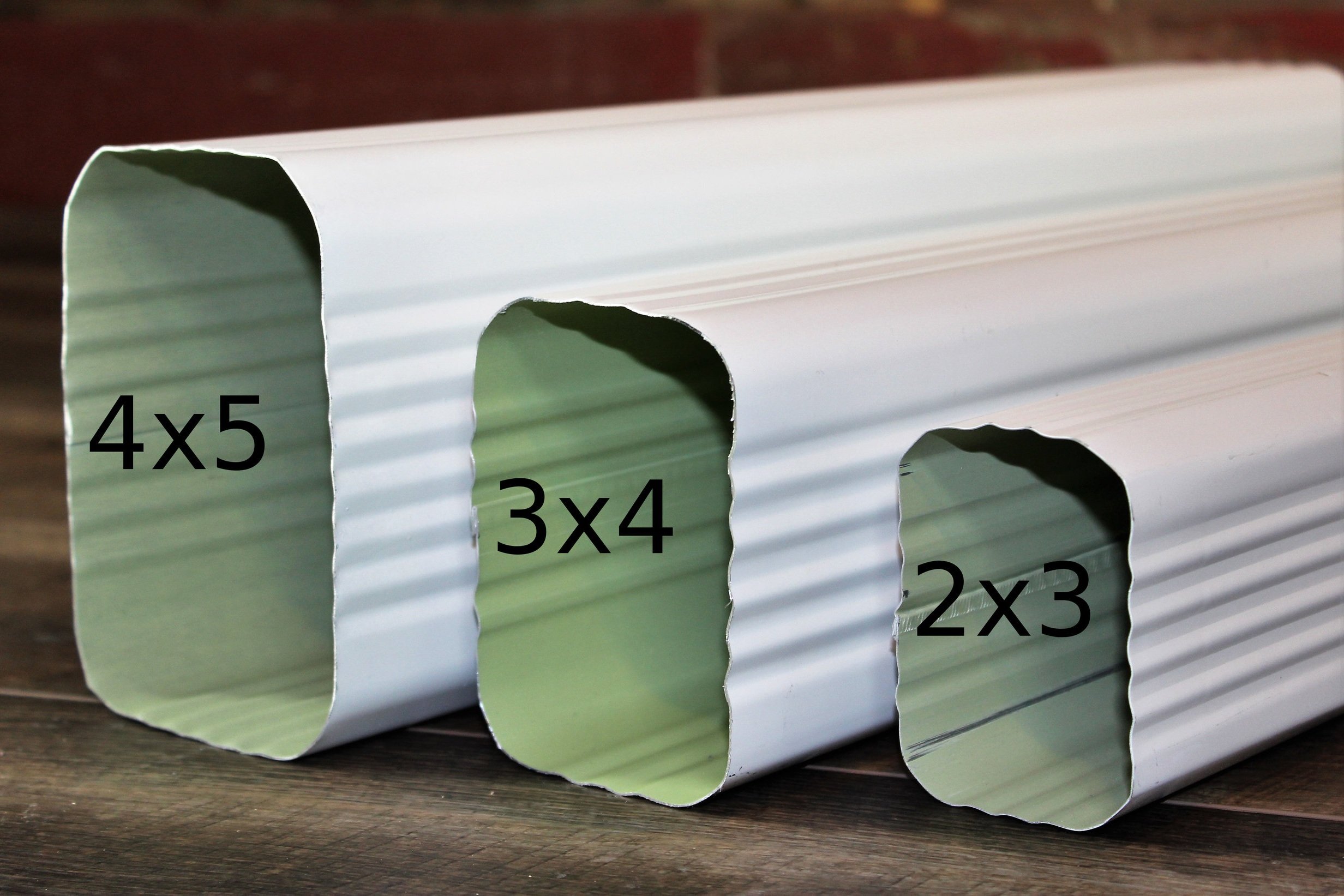 A silver, corrugated metal roll with cut-out sections labeled with multiplication equations, resting on a wooden surface.