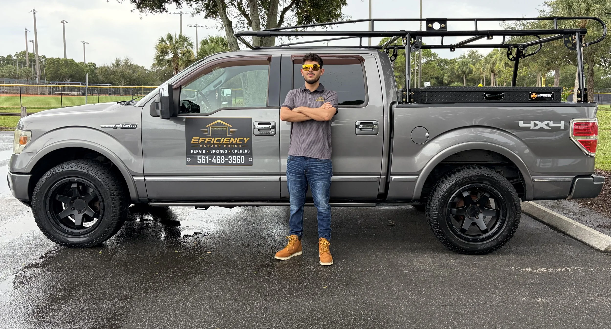 Owner of Efficiency Garage Doors standing in front of a fully equipped service truck in West Palm Beach, Florida.