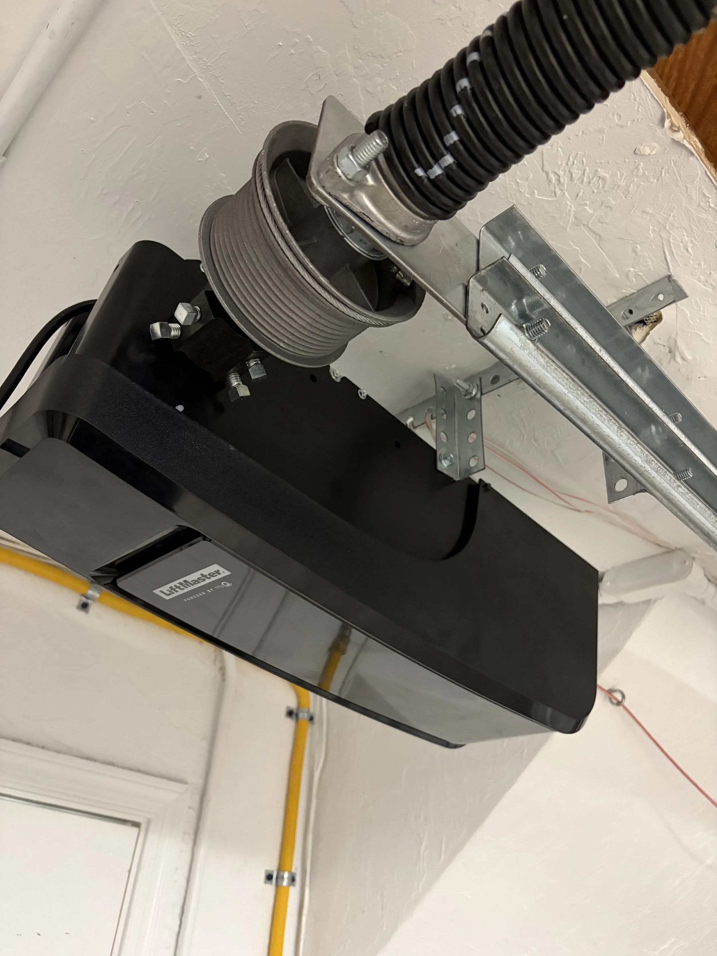 LiftMaster garage door opener professionally installed on the ceiling in a residential garage in West Palm Beach, Florida.