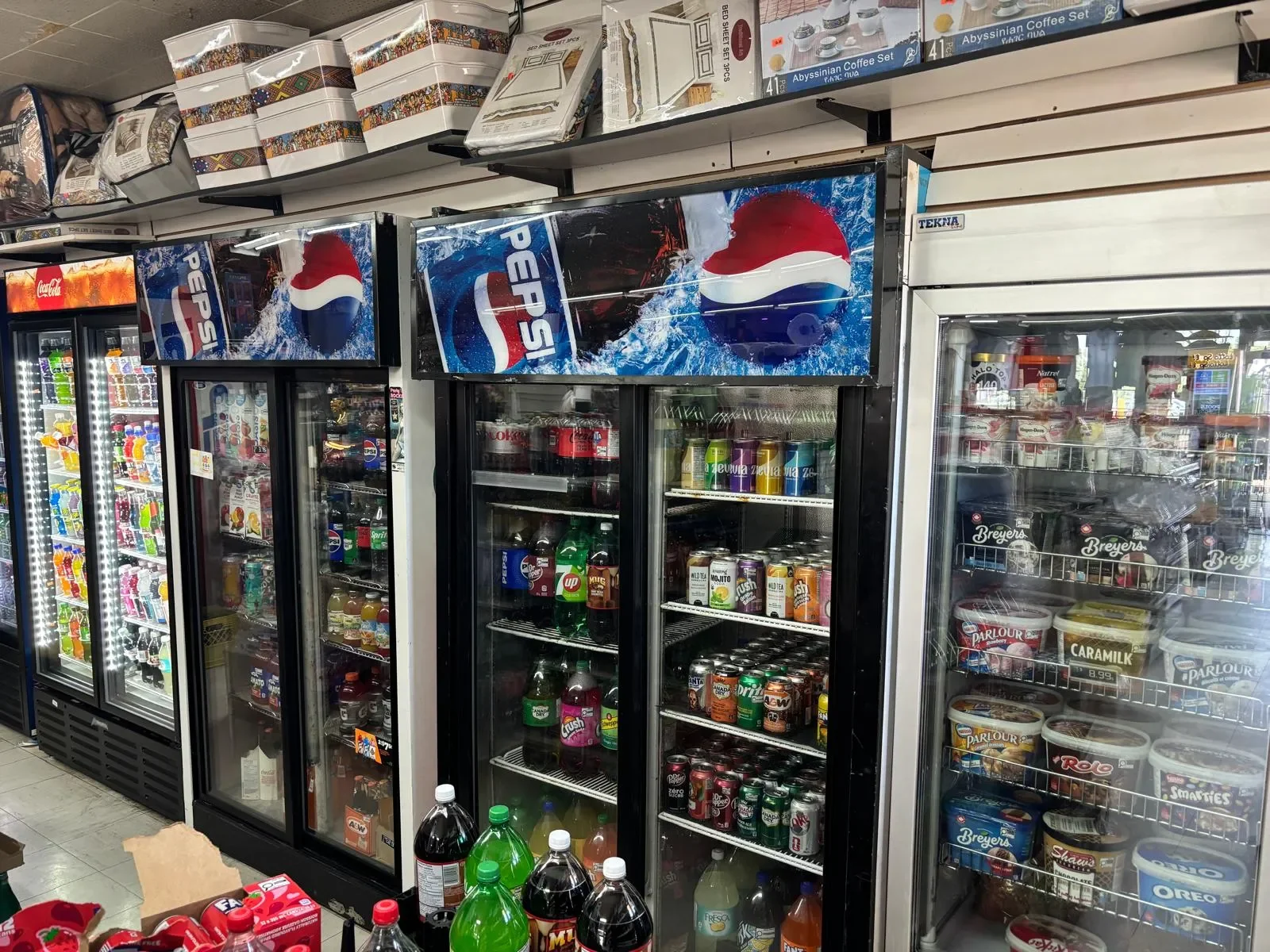 Refrigerated beverage showcase at Athlon Food Store in Edmonton featuring soft drinks, bottled water, energy drinks, juices, iced tea, and other chilled beverages.