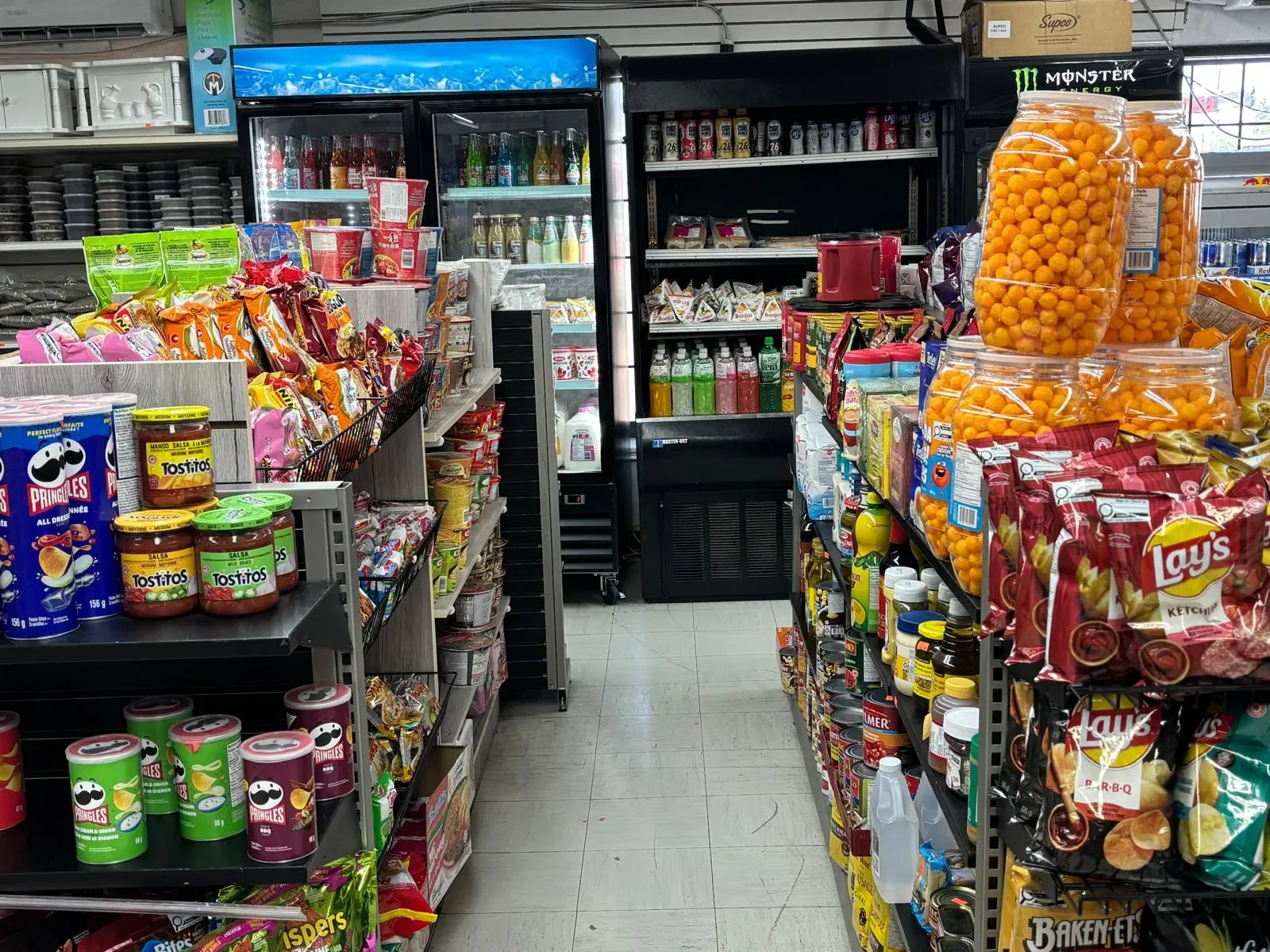 Modern convenience store interior at Athlon Food Store in Edmonton offering groceries, snacks, beverages, tobacco products, clothing, ATM services, Bitcoin ATM, lottery, and U-Haul rentals.