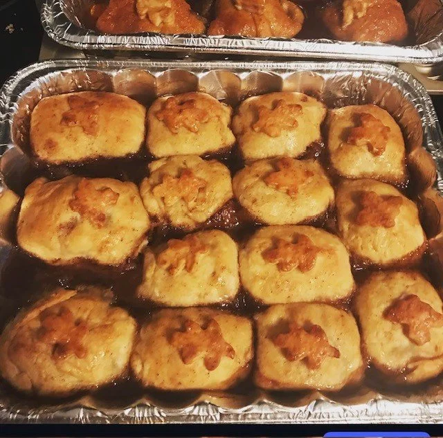Tamales topped with melted cheese in aluminum tray