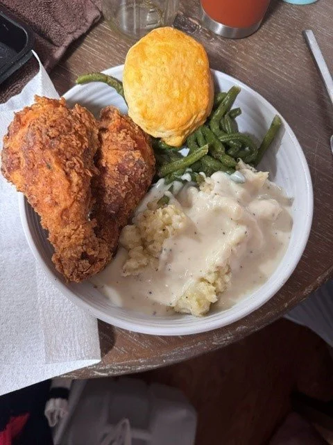 Plate of fried chicken, green beans, cheesy potatoes, and a cornbread muffin