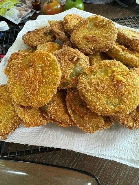 Fried food, possibly chicken and vegetables, on a paper towel-lined tray.