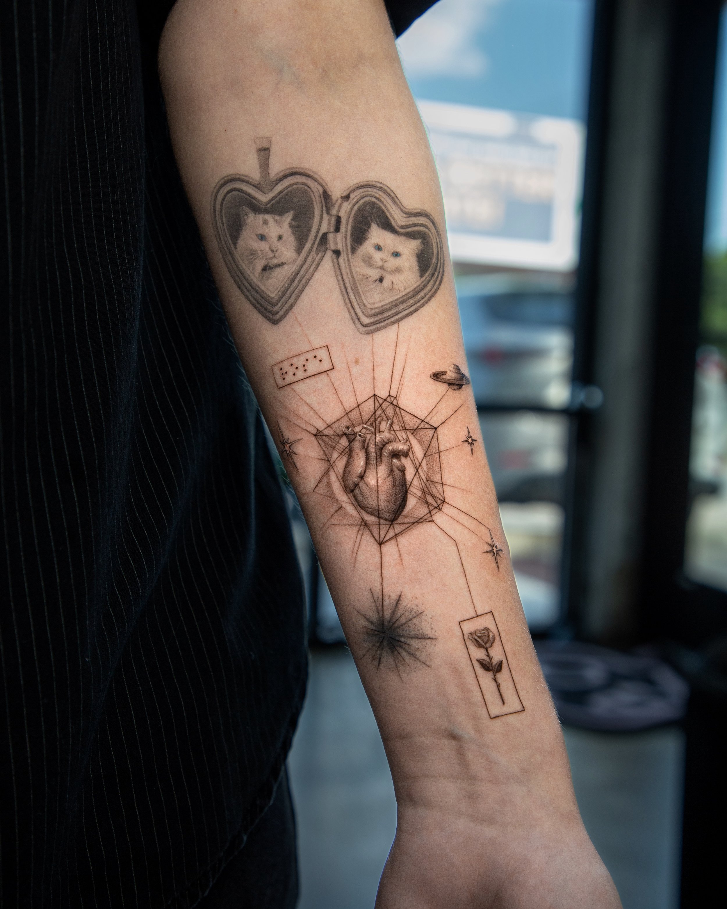 A hyper realistic tattoo done by Ihor (flowerhead.ink) on person's forearm. Featuring a realistic heart inside of a clean birth chart, connected to other tattoos with fine lines.