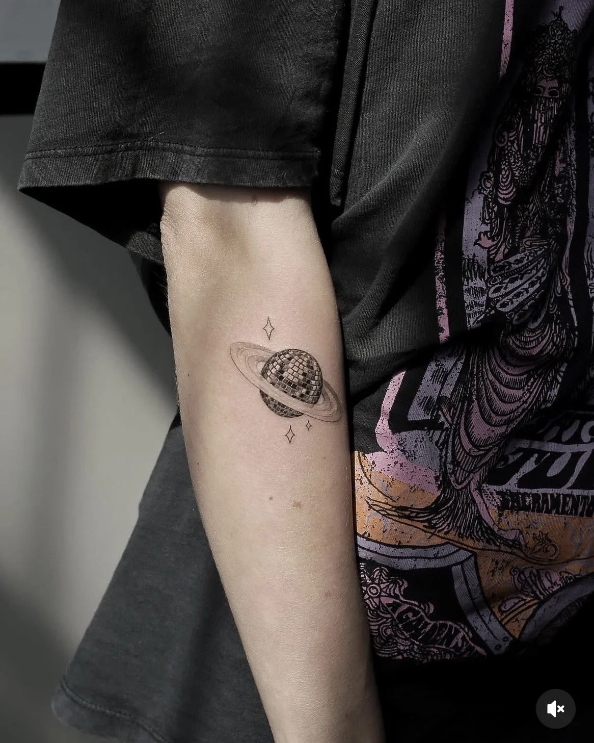 A hyper realistic tattoo done by Ihor (flowerhead.ink) on person's forearm. Featuring a disco ball Saturn and small stars.