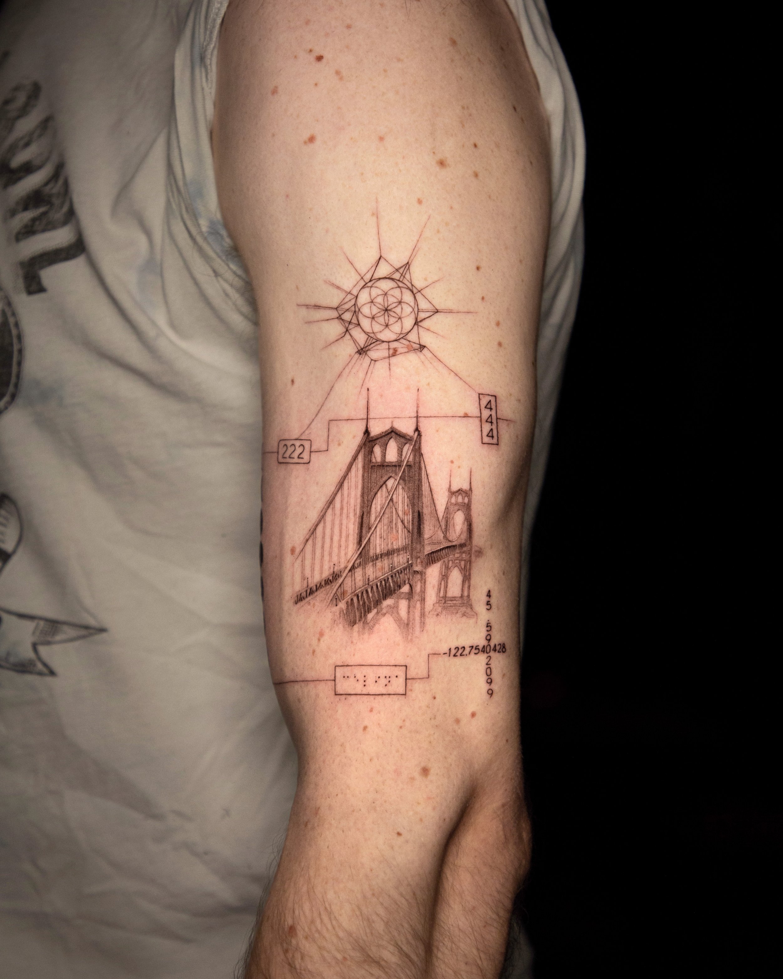 A hyper realistic tattoo done by Ihor (flowerhead.ink) on person's upper arm. Featuring a fine line bridge and some personal details - birth chart, braille text, angel numbers, etc.