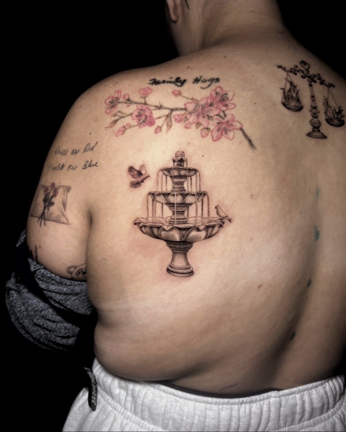 A hyper realistic tattoo done by Ihor (flowerhead.ink) on a person's back. Featuring a close-up of a European renaissance water fountain. 