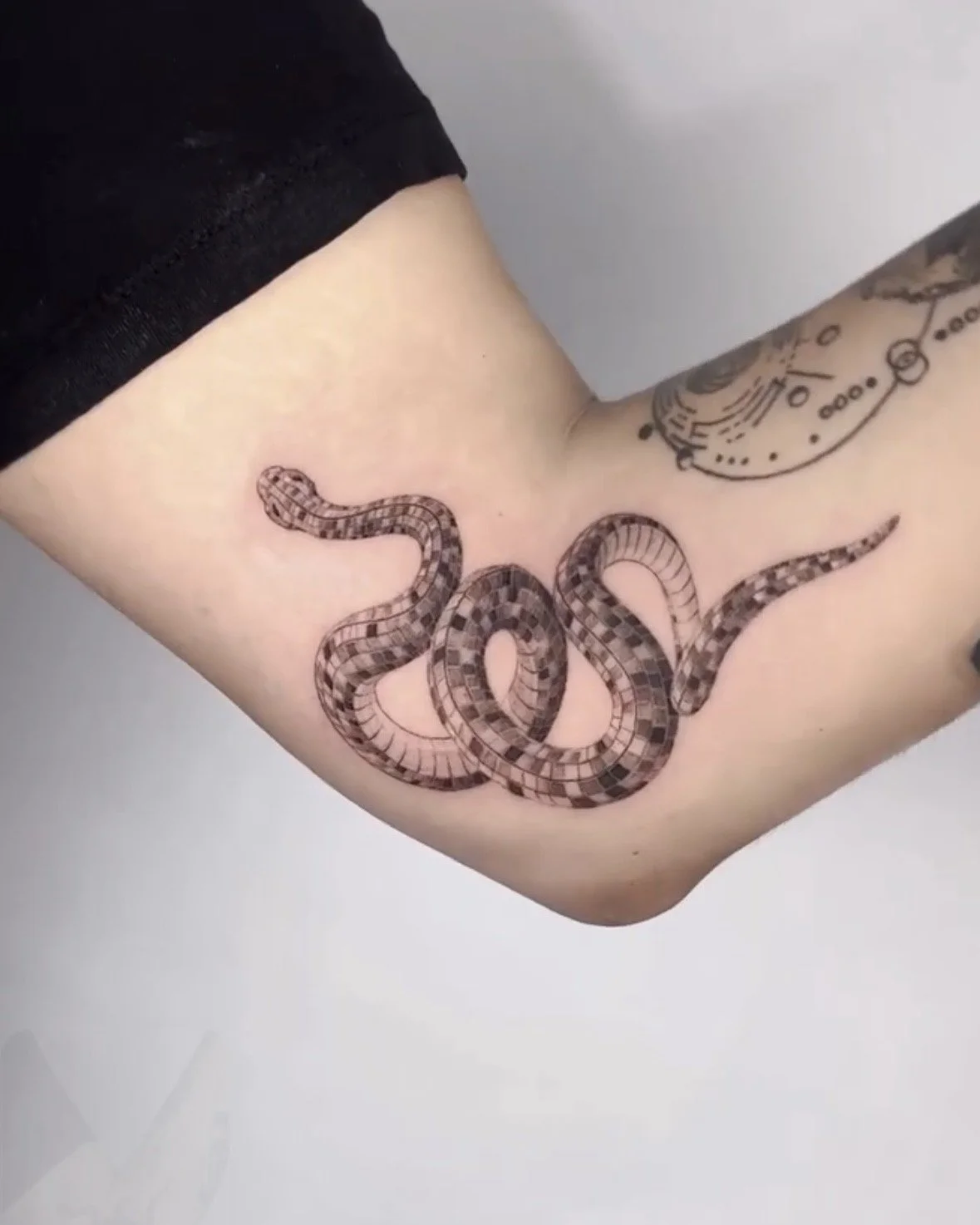 A hyper realistic custom tattoo done by Ihor (flowerhead.ink) on person's inner elbow. Featuring an original snake tattoo with a disco ball texture.