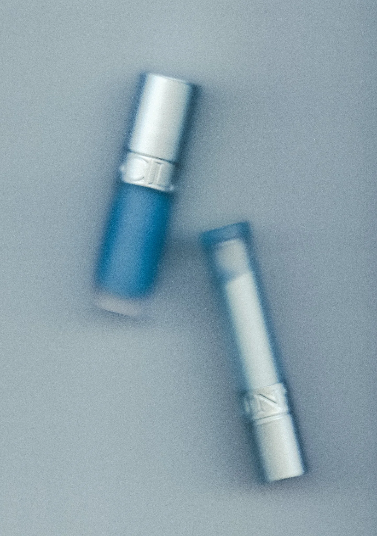 Close-up view of a metallic dental handpiece against a gray background.