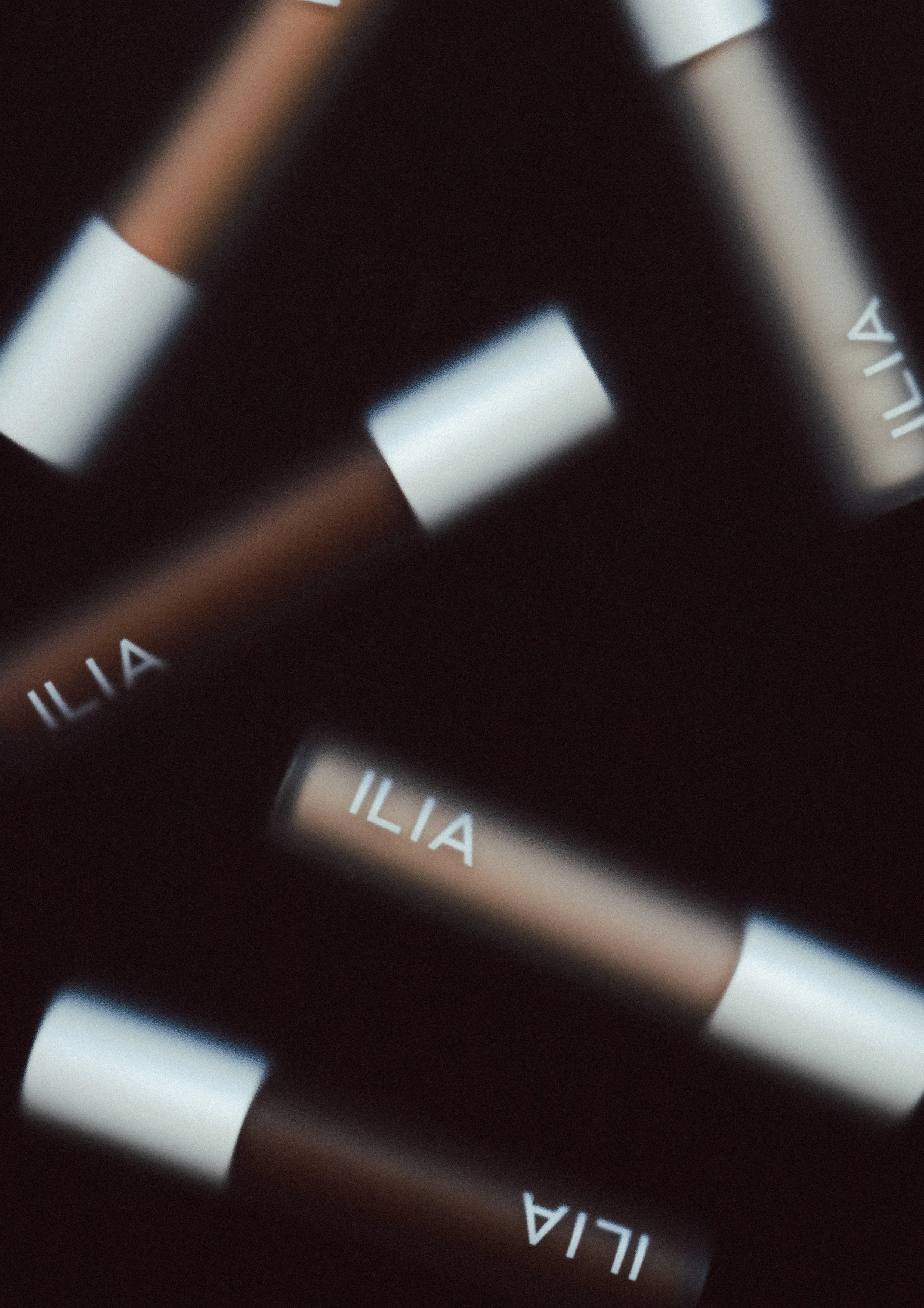 Close-up of a watch face with the brand name 'ILIA' visible, showing a blurred and abstract perspective.